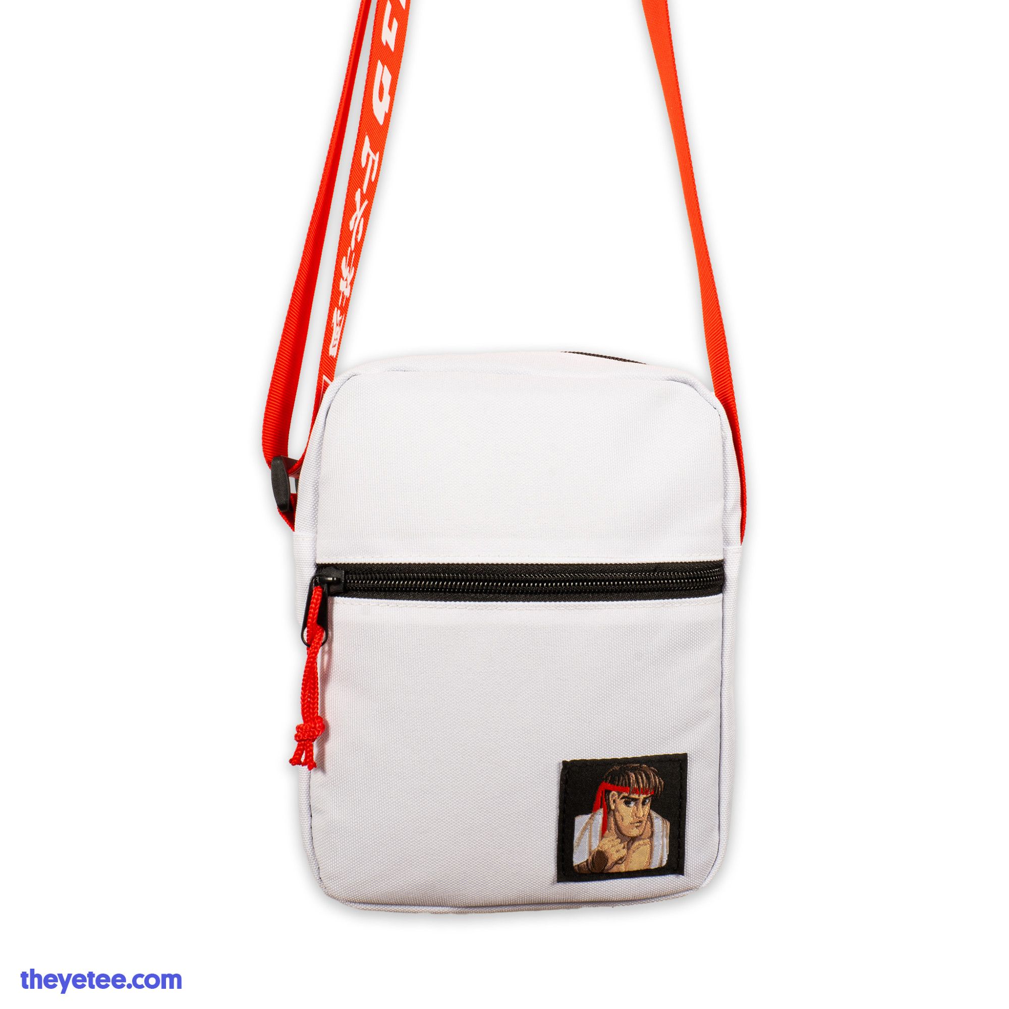 A front photo of a White Street Fighter 2 Ryu shoulder satchel. There is a square patch of Ryu's fighter icon in the bottom right corner. There is a zipper on the front with a Red cord.