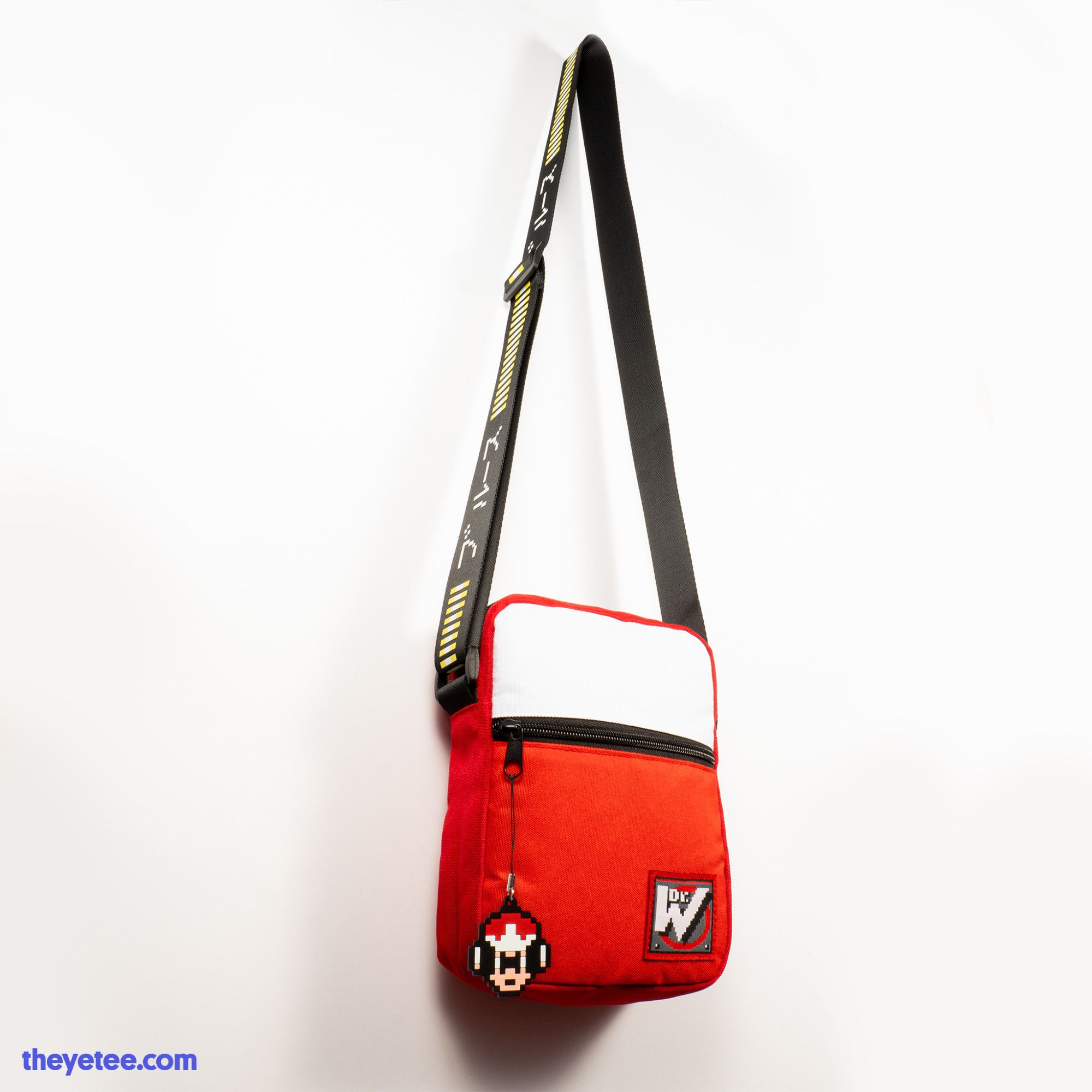 Red Protoman (From Mega Man) Shoulder Bag. It is red with a white accent. There is a Dr. Wily patch in the bottom corner. It also features a Protoman Zipper Pull. The strap is black and has a printed energy bar on it.