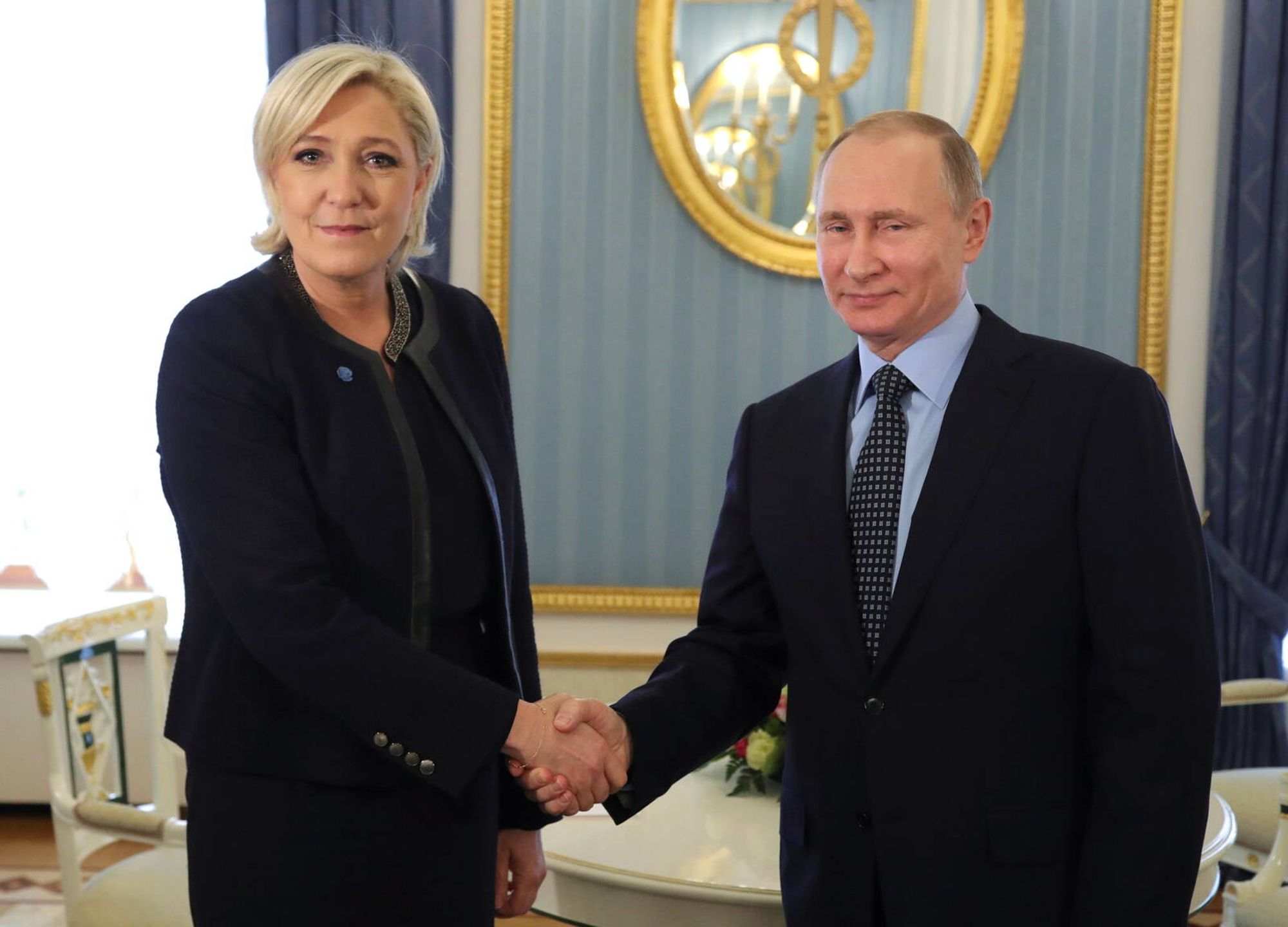 Eine Photo-Op der RN, wo sie Putin extra eingeladen haben, um dieses Bild schießen zu können, in dem eine strahlende Marine Le Pen und ein feixender Putin sich die Hände schütteln.