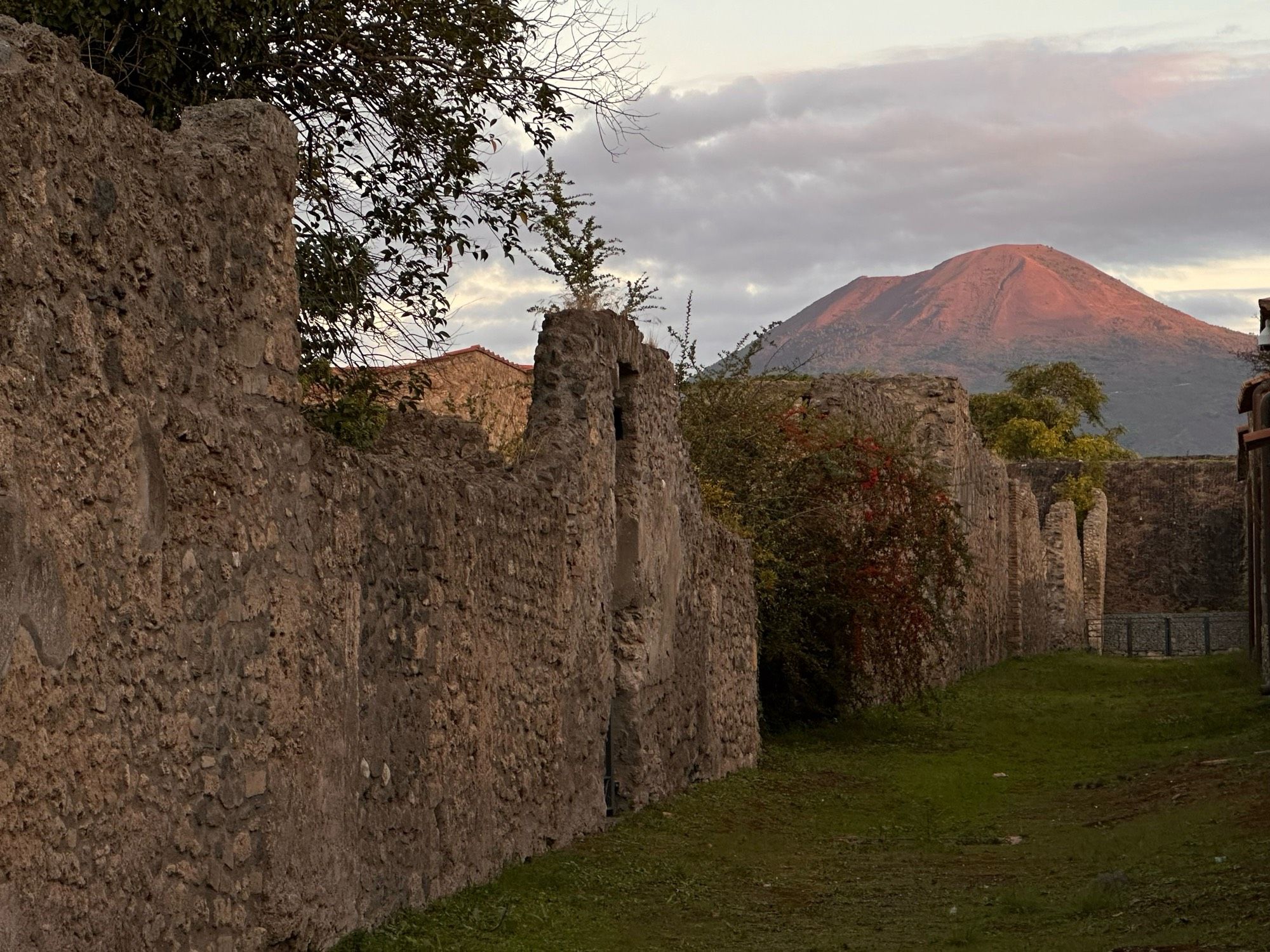 View up a road in Pompeii and the red morning light lighting the top of Vesuvius