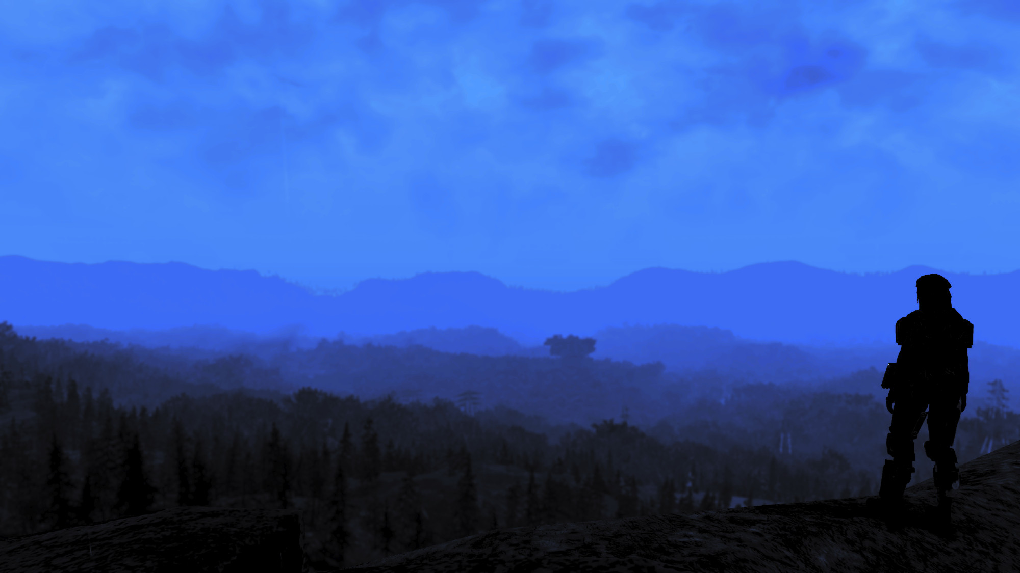 A picture from the Fallout 76 photomode with a character's silhouette standing before a layered forest and mountain landscape.