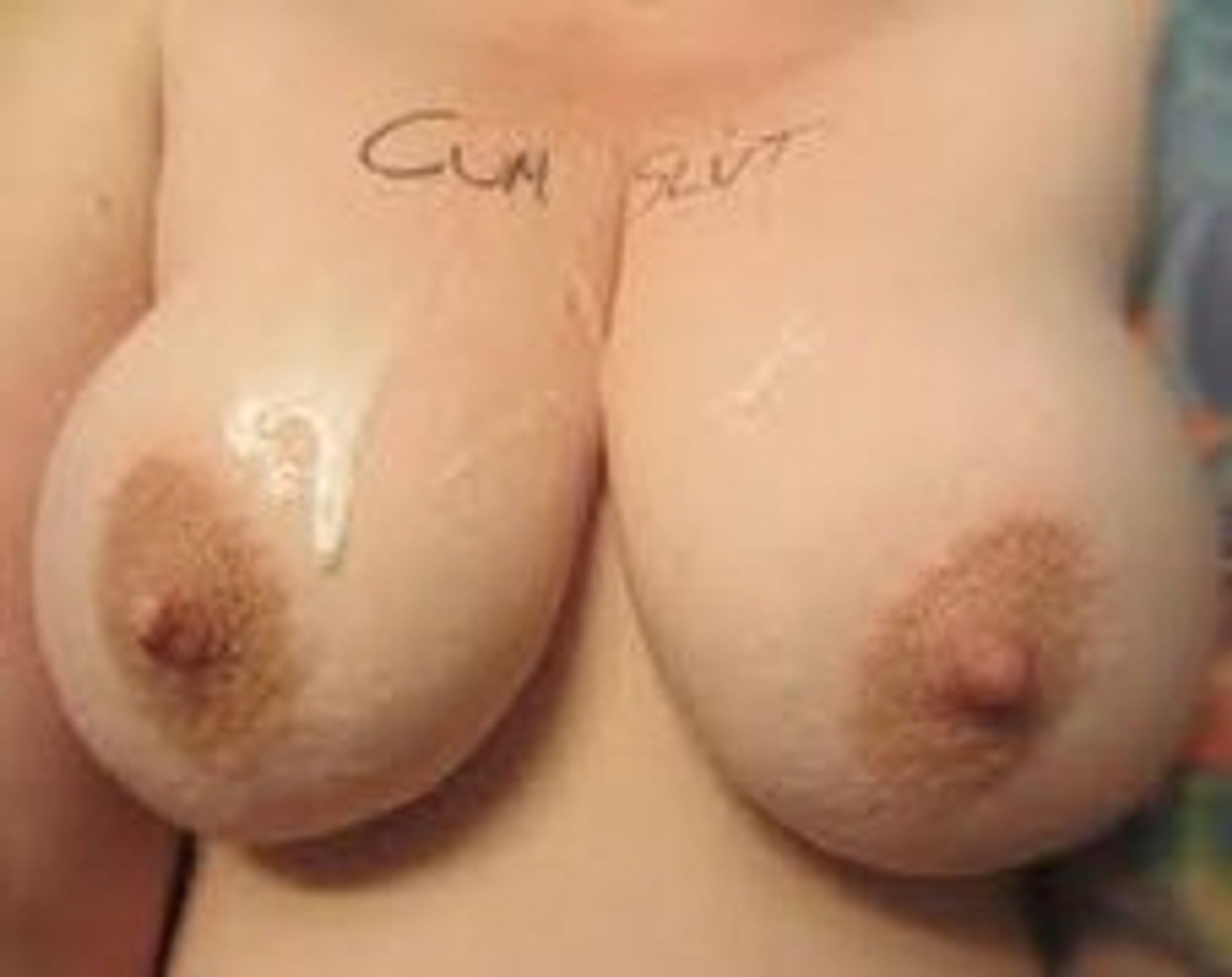 big tits with "cum slut" written on them and cum dripping on them