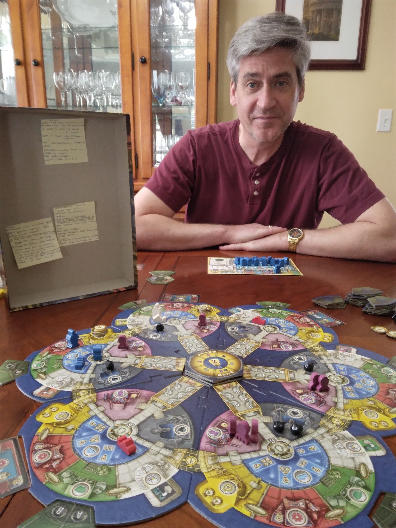 Man with Aquasphere central board and box with setup and rules post-its