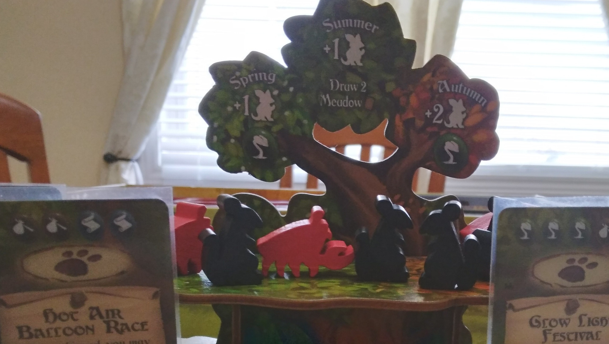 Everdell tree with rat and crab meeples. They are used to represent the solo meeples in Everdell.