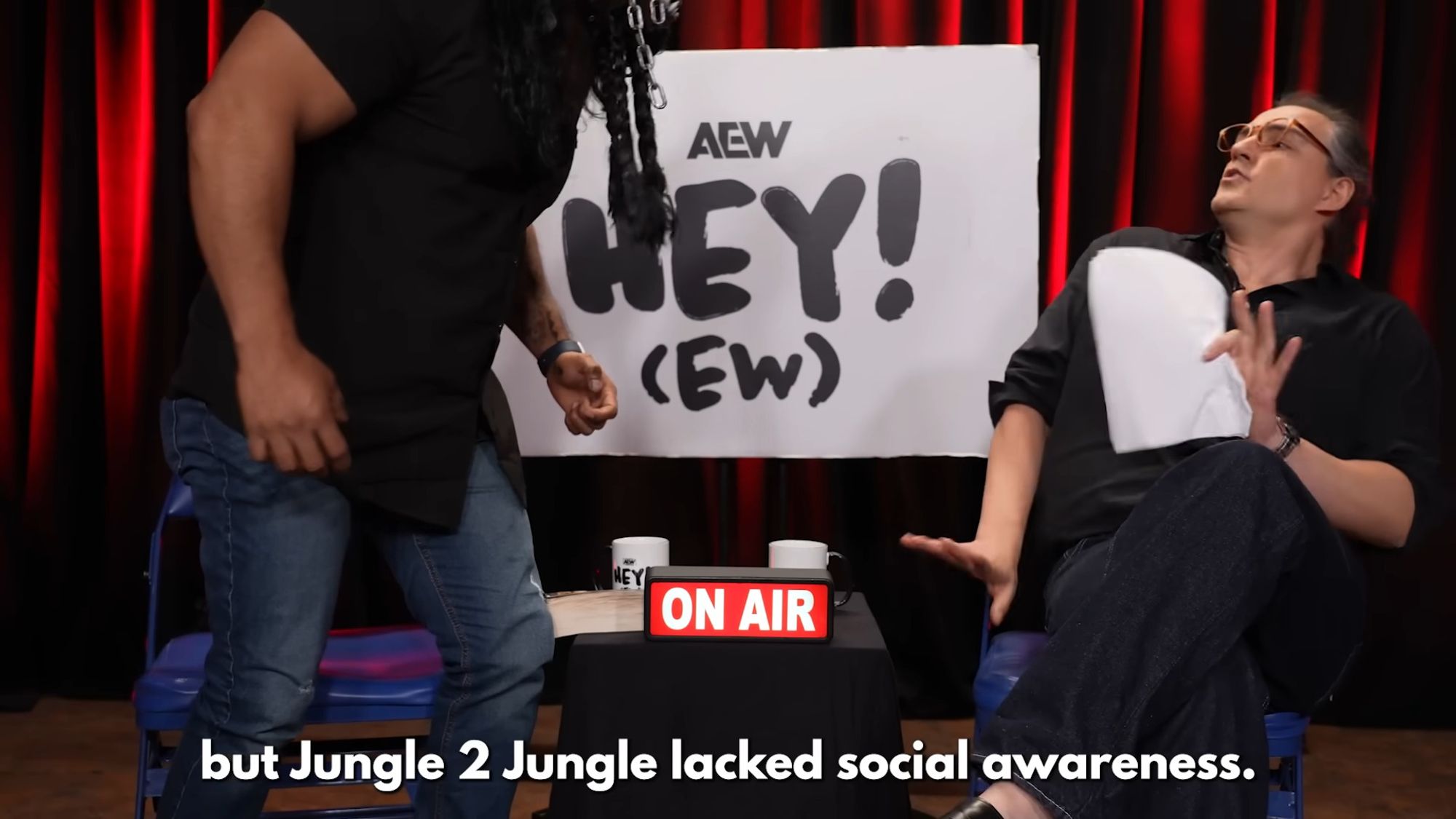 RJ City and The Beast Mortos in front of an AEW Hey! (EW) sign with an ON AIR sign on. Caption is "but Jungle 2 Jungle lacked social awareness."