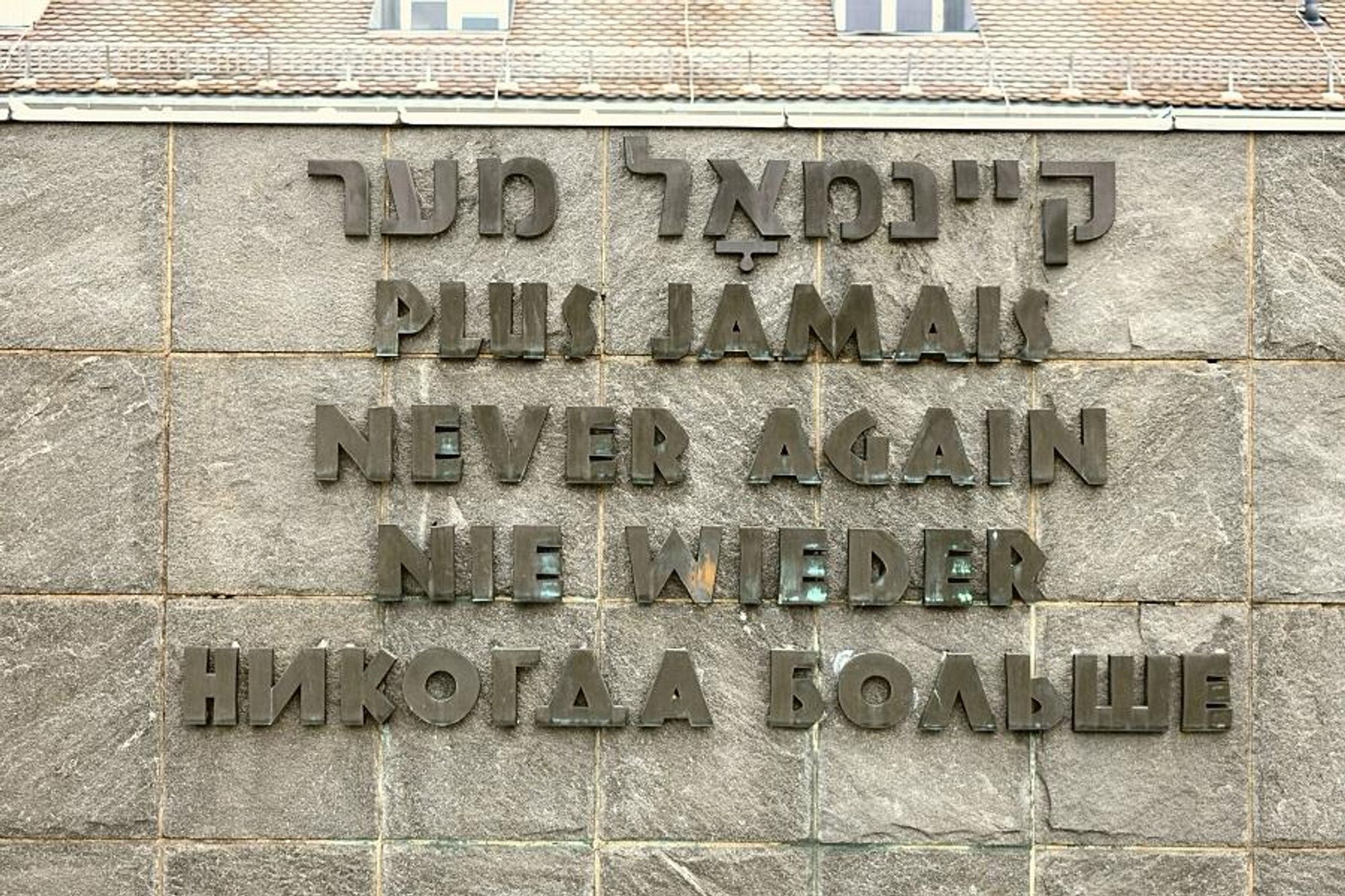 „Nie wieder“-Schriftzug in mehreren Sprachen an der Gedenkstätte des Konzentrationslagers Dachau.