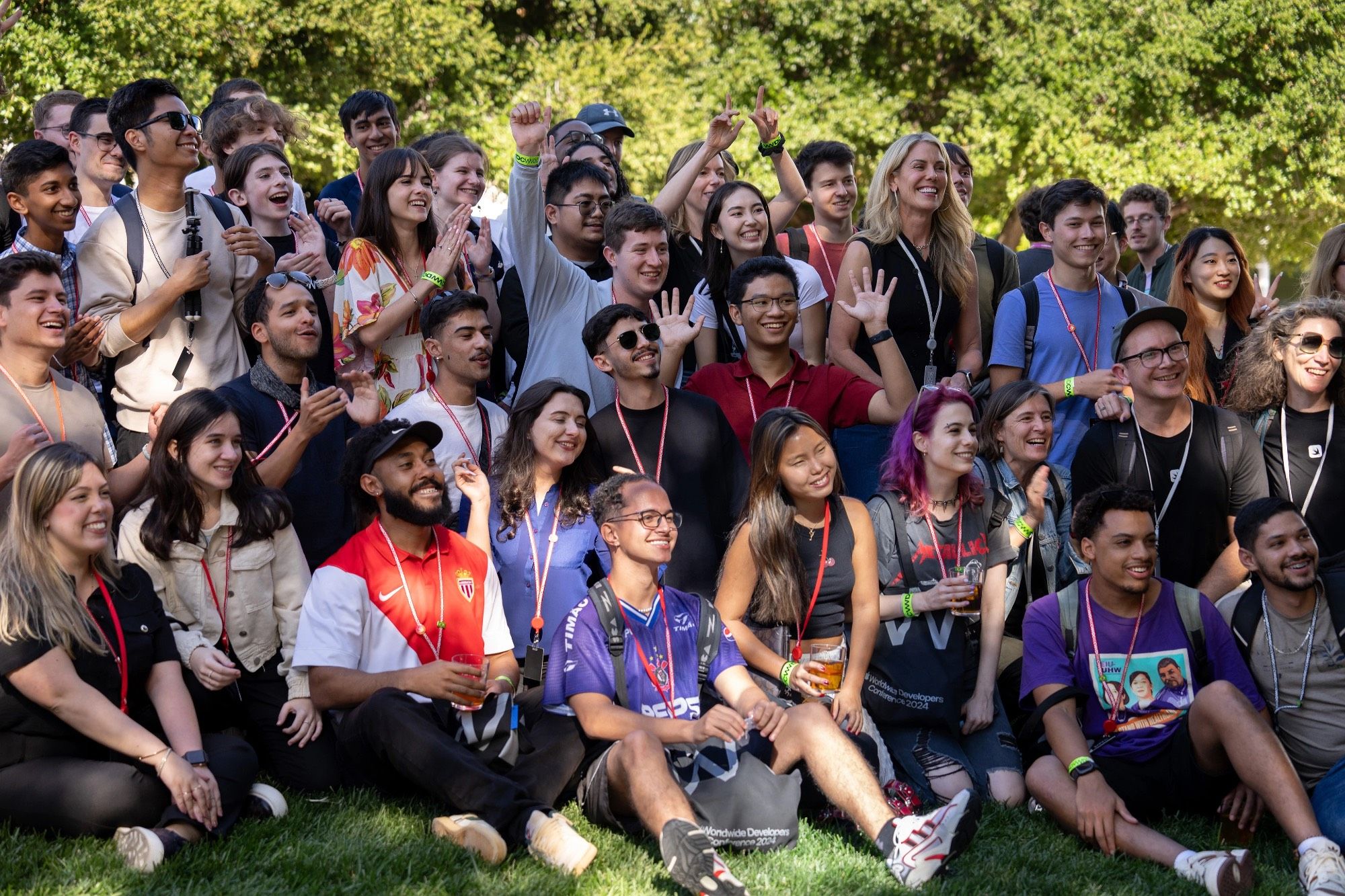 Group of Swift Student Challenge Winners on a lawn with WWDC lanyards