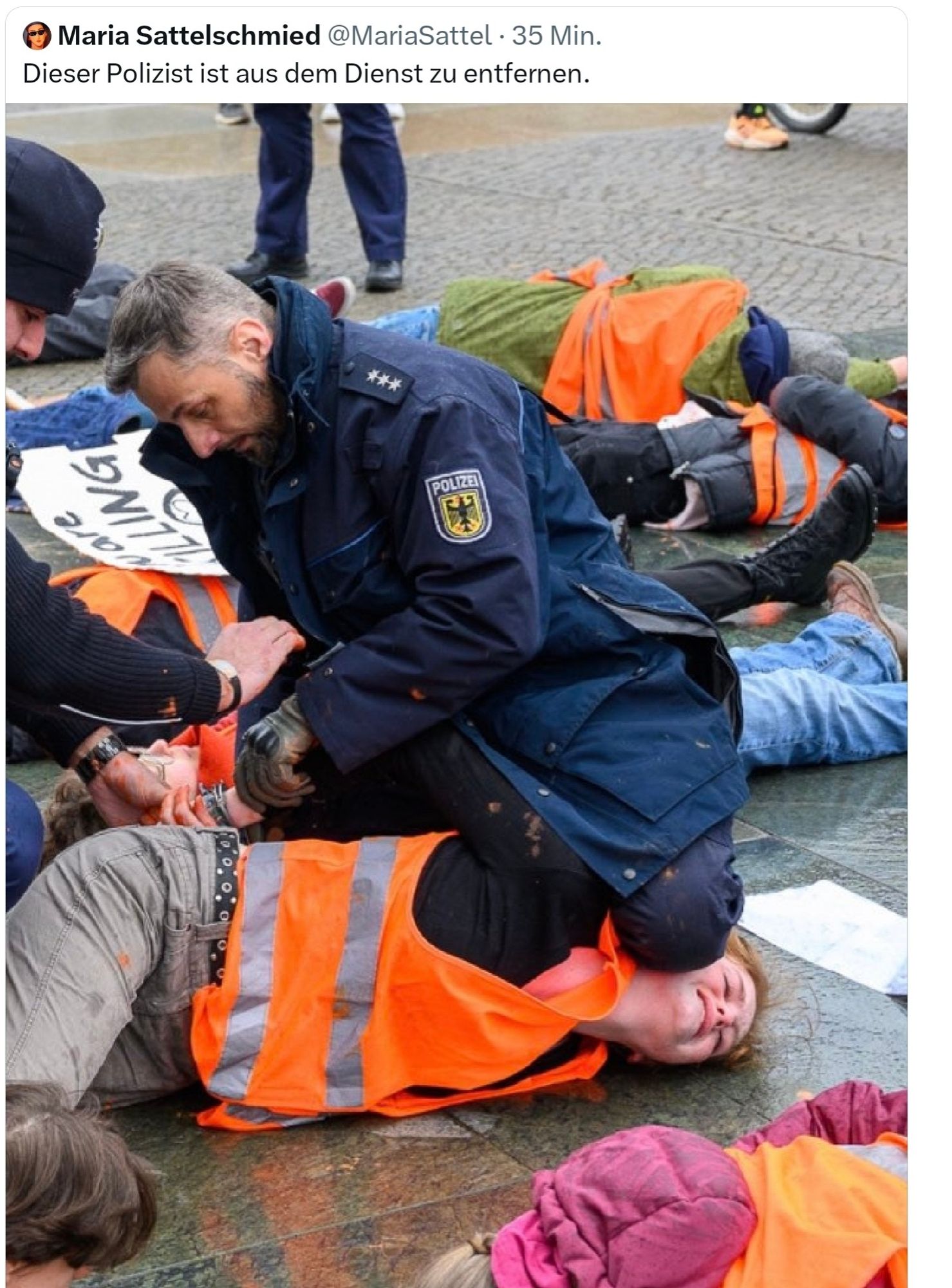 Polizist knebelt mit Knie auf dem Kopf eine gewaltfreie Demonstrantin