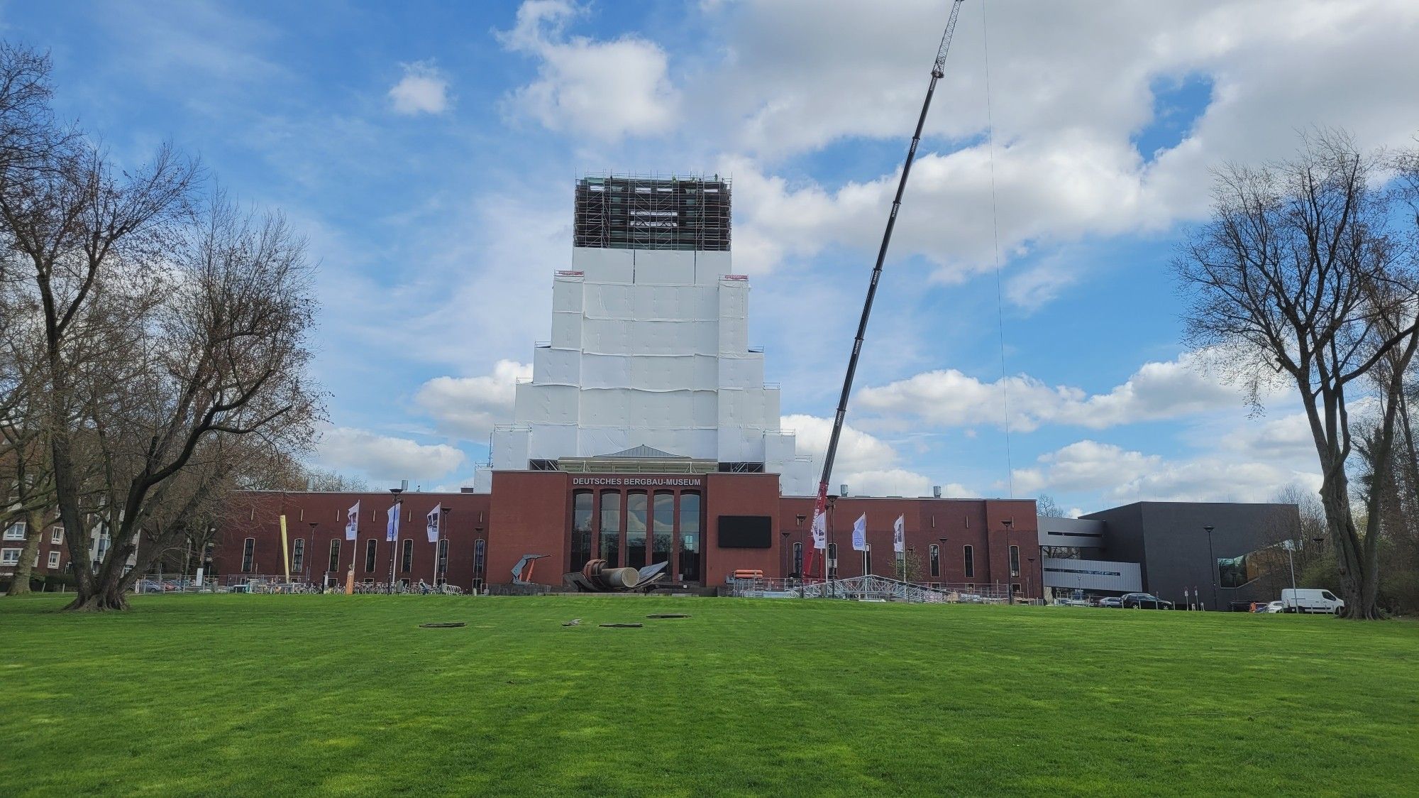 Förderturm mit Gerüst und fast vollständig mit weißen Planen eingehüllt für anstehende Restaurationsarbeiten