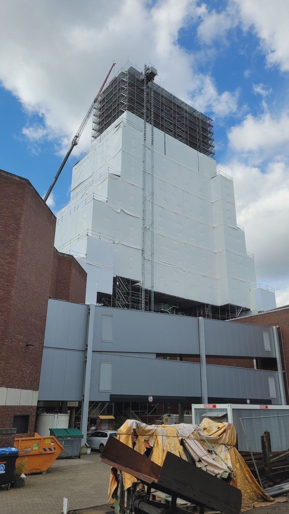 Förderturm mit Gerüst und fast vollständig mit weißen Planen eingehüllt für anstehende Restaurationsarbeiten