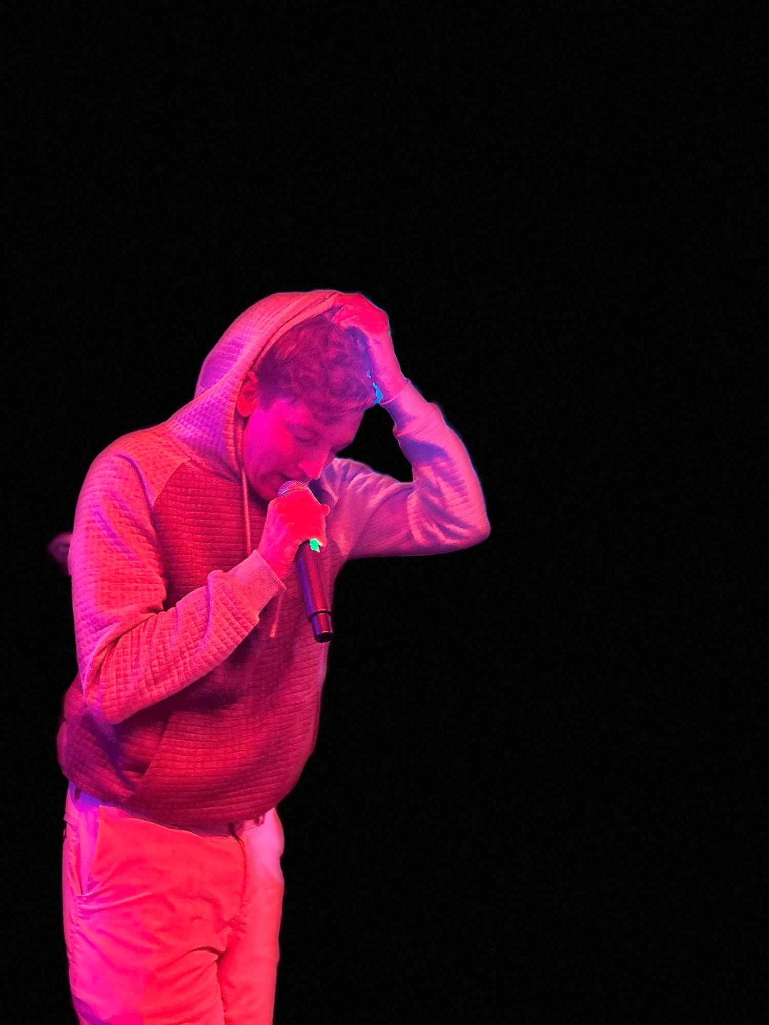 A man in red light holding a microphone