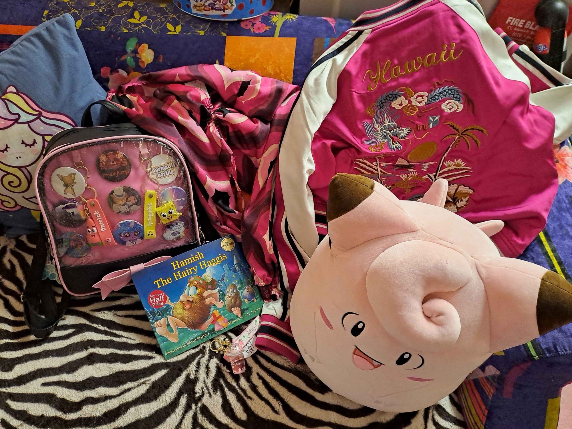 i got two pink tops (one hawaiian), a giant clefairy squishmallow, Hamish The Hairy Haggis storybook, sakura bubble milk tea keychain, and some evian water. the ita bag was the bag i took with me to Nessie's city :3