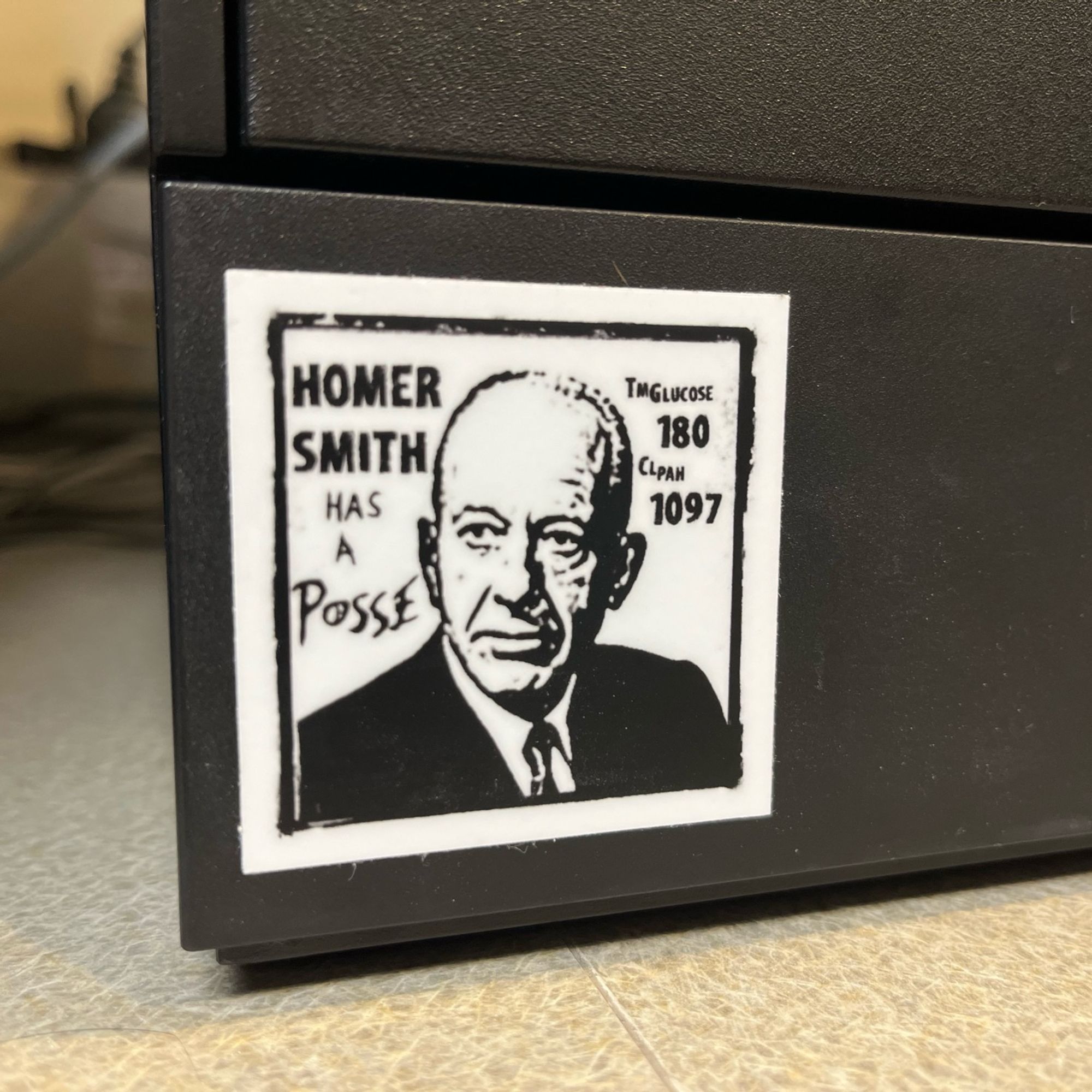 Sticker on the side of a dialysis unit printer: Black and white portrait of Homer Smith, text “Homer Smith has a posse”