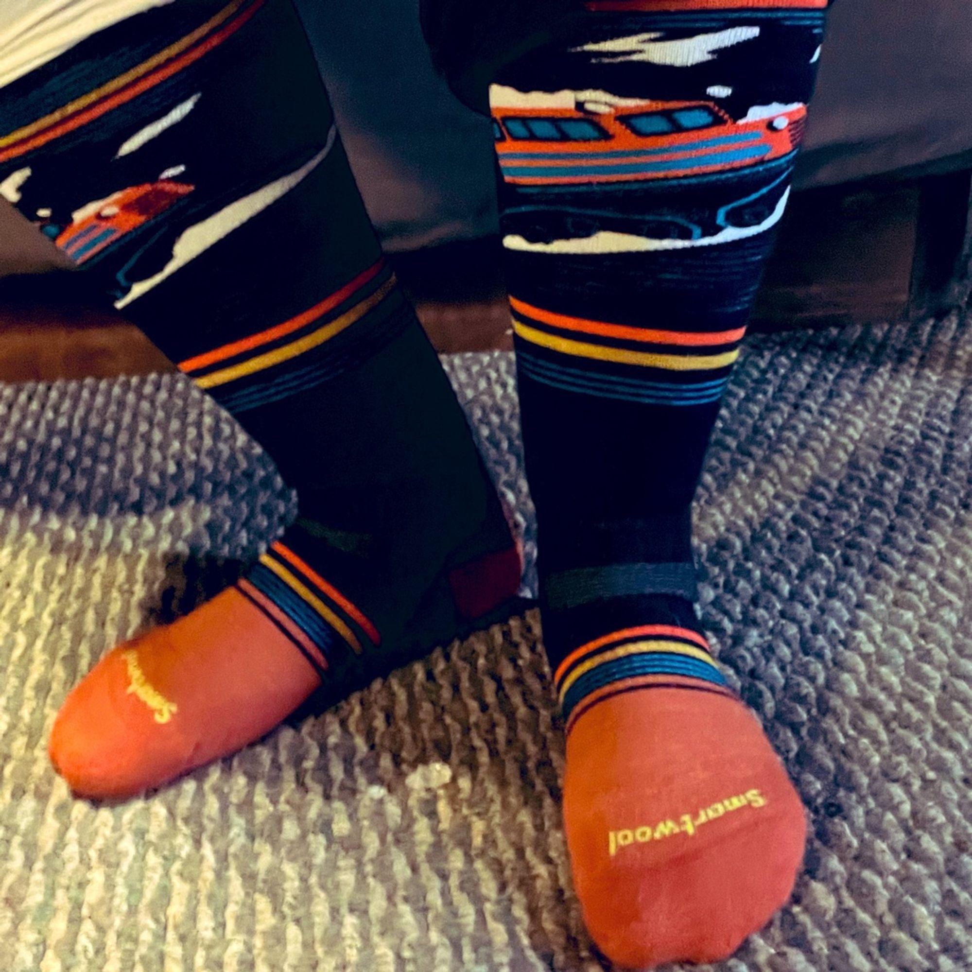 My very cold, sweaty feet in wool ski socks (orange and black w/ yellow + blue stripes and a slow ?plow thingy)