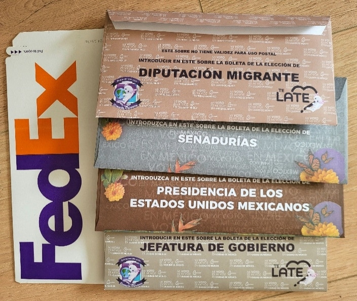 Cuatro sobres para las elecciones: diputación migrante, senadurías, presidencia y jefatura de gobierno. Los sobres están sobre un sobre de FedEx.