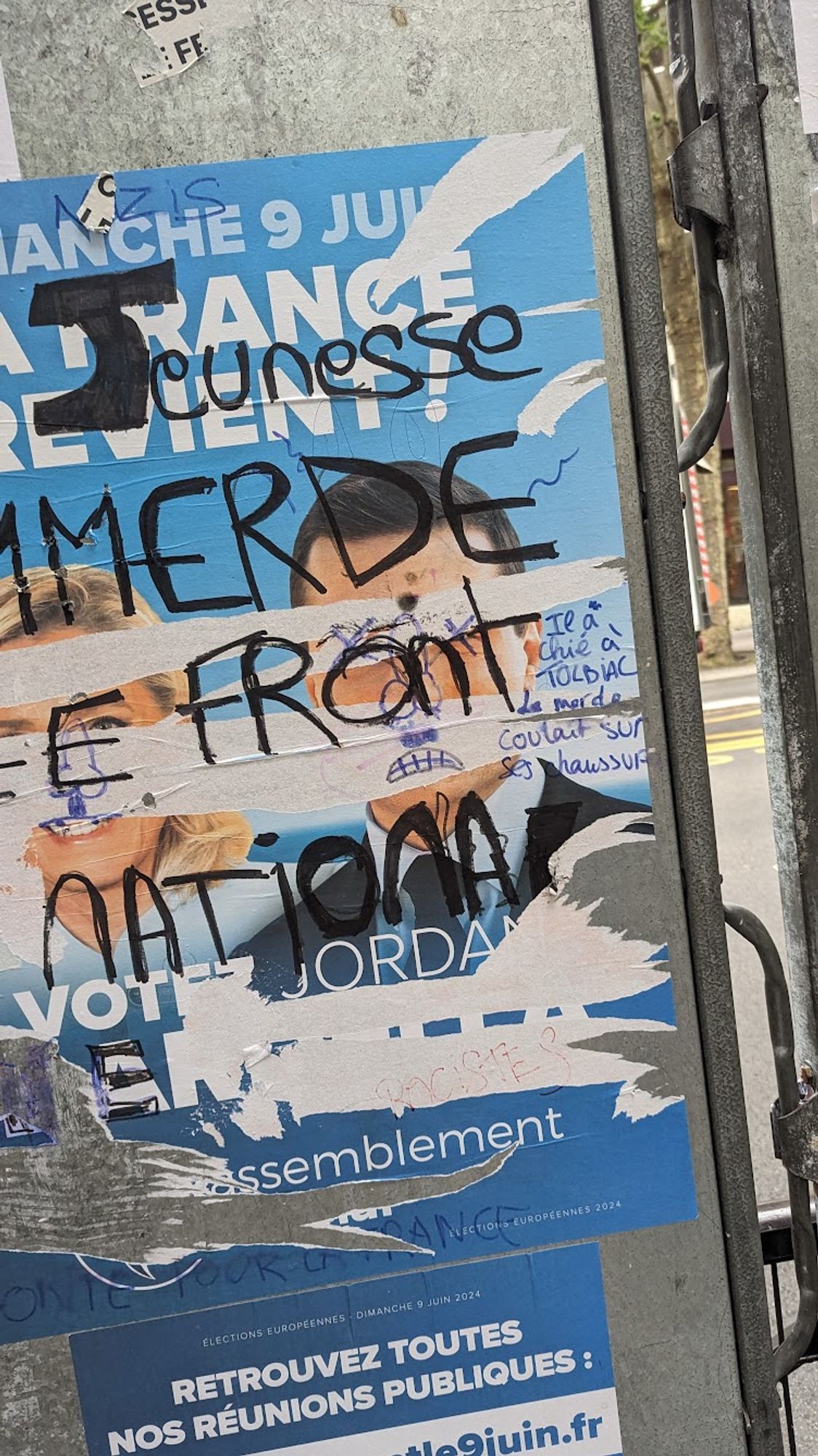 affiche électorale du RN, vandalisée. Un des graffiti explique "il a chié à Tolbiac la merde coulait sur ses chaussures"