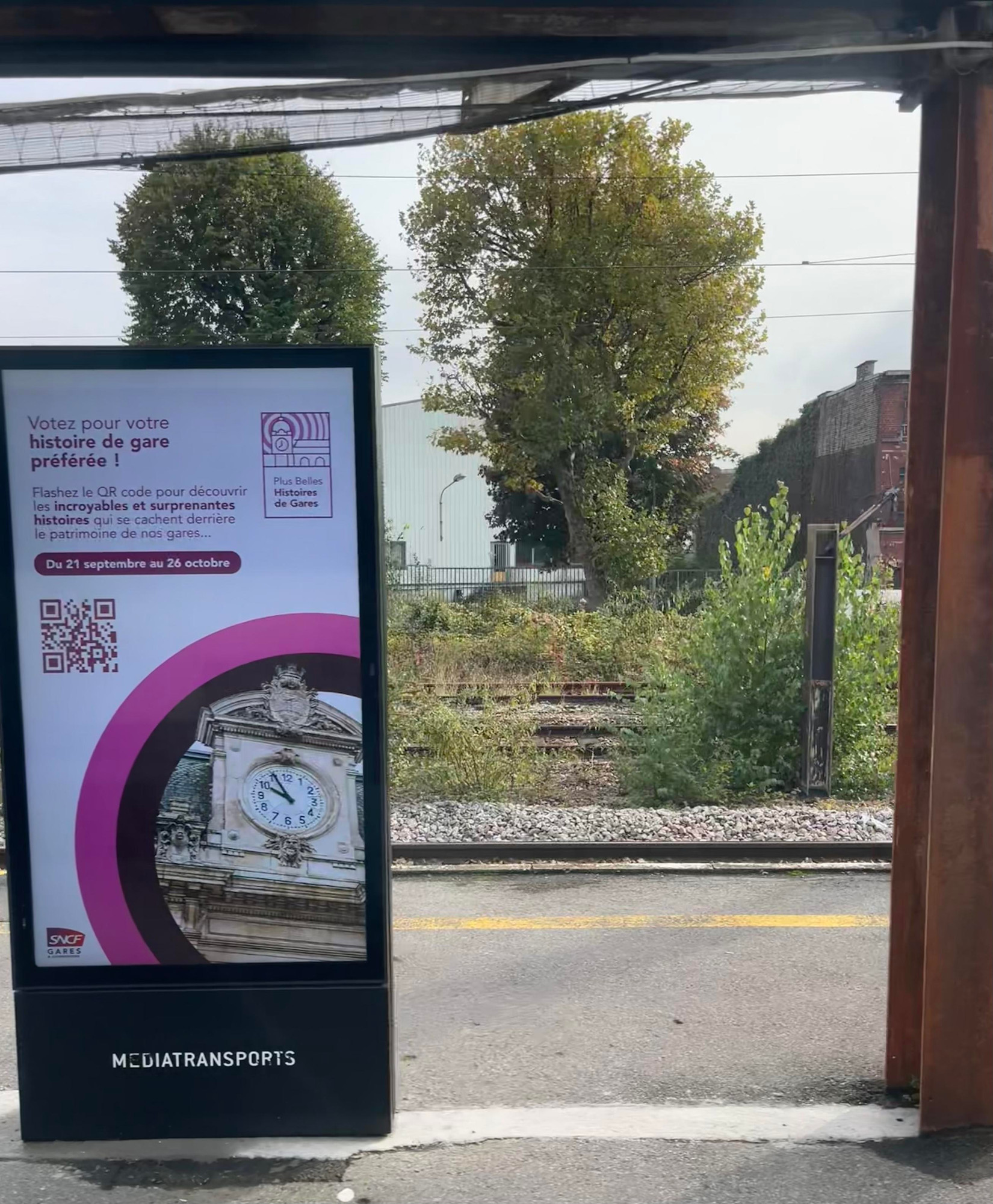 LCD screen to the left:
Votez pour votre
histoire de gare
préférée !
Flashez le QR code pour découvrir
les incroyables et surprenantes
histoires qui se cachent derrière
le patrimoine de nos gares...
Du 21 septembre au 26 octobre
Plus Belles
Histoires
de Gares
S
.6
SNCF
GARES
MEDIATRANSPORTS

Rusty pillar right 