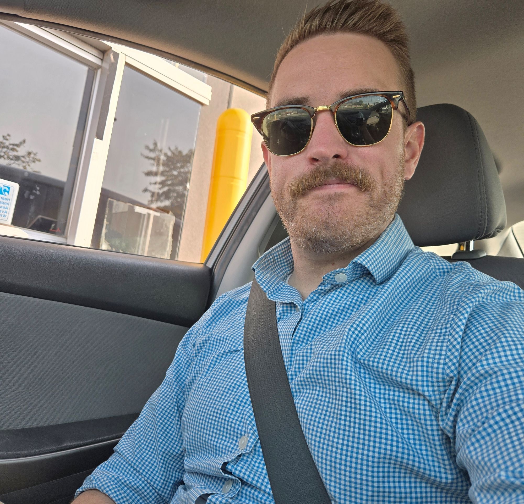 Selfie of Jake in a car, ostensibly at a McDonald's drive through window