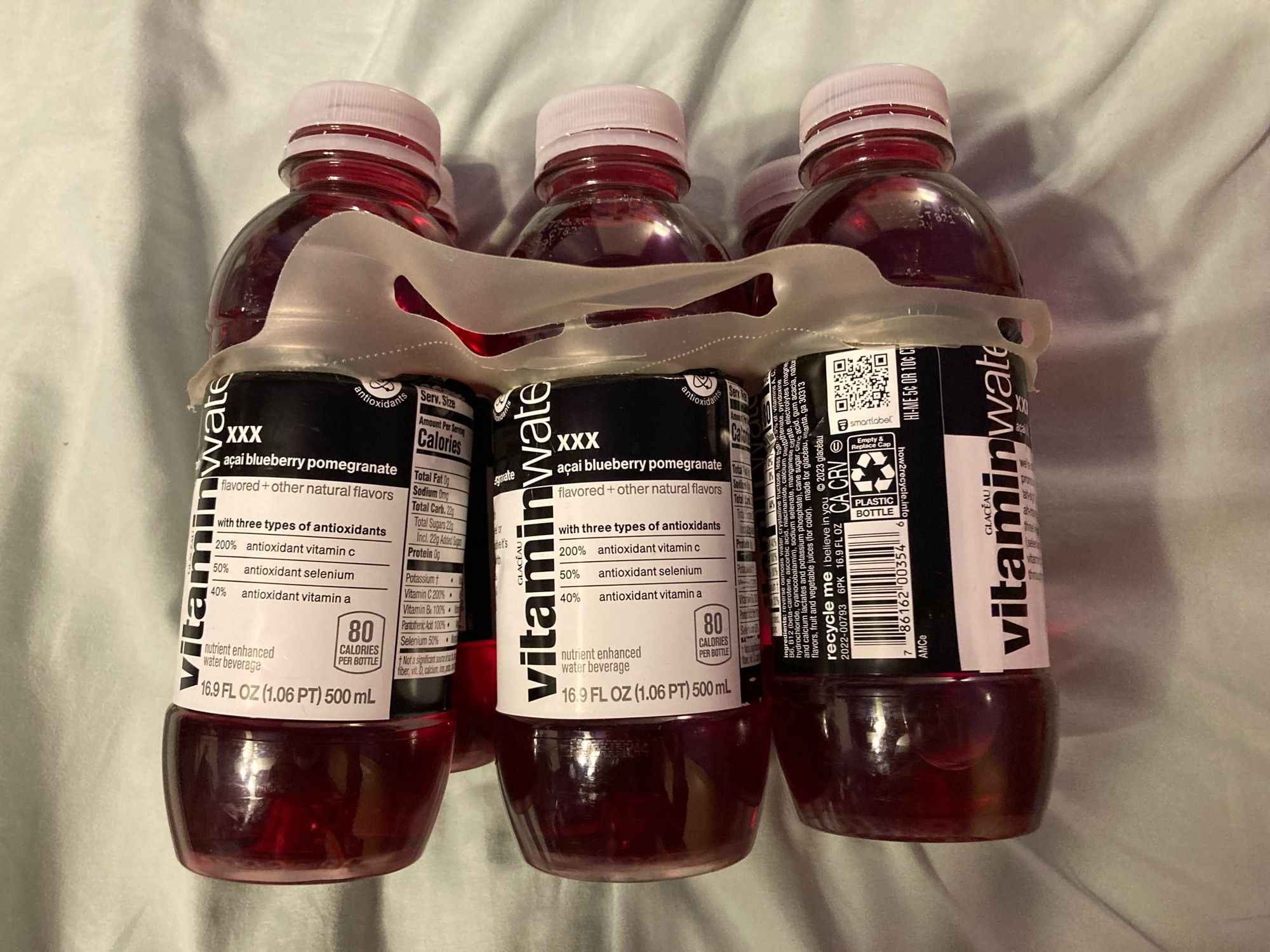 A six-pack of VitaminWater XXX bottles from the side.