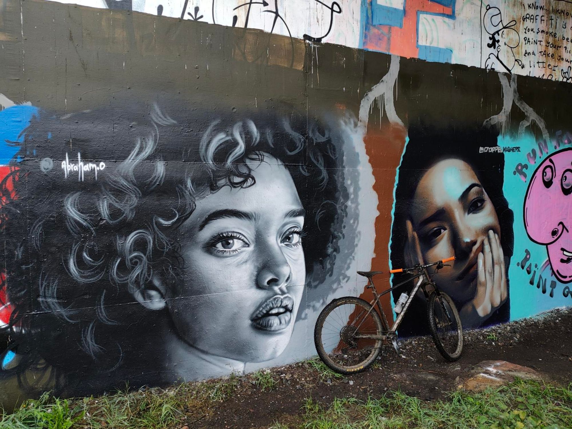 Urban art under a road. 2 images of women's faces.