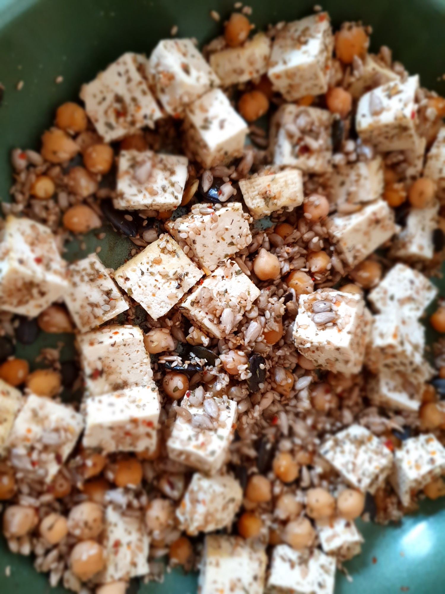 Tofu, Sämereien & Kichererbsen in einer grünen Pfanne von oben fotografiert 