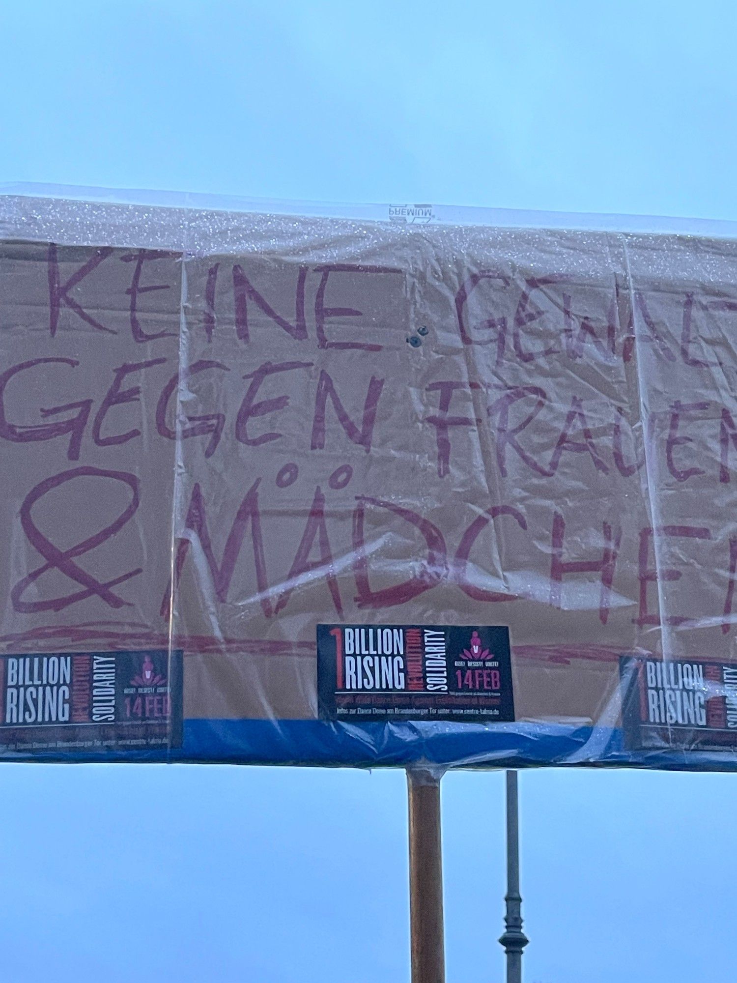 Ein Plakat auf der One Billion Rising Demonstration vor dem Brandenburger Tor.