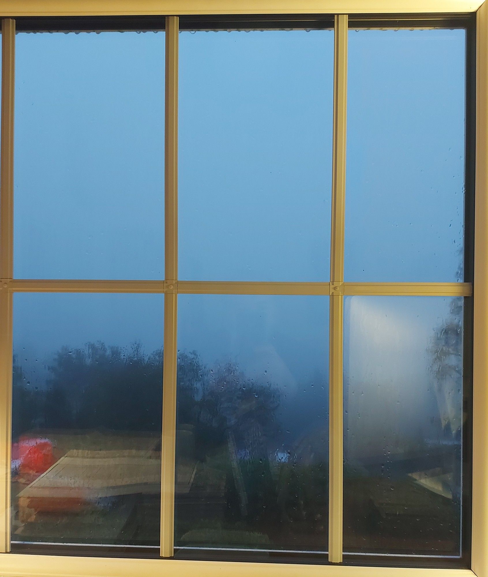 Photo through a window, of a densely foggy evening.