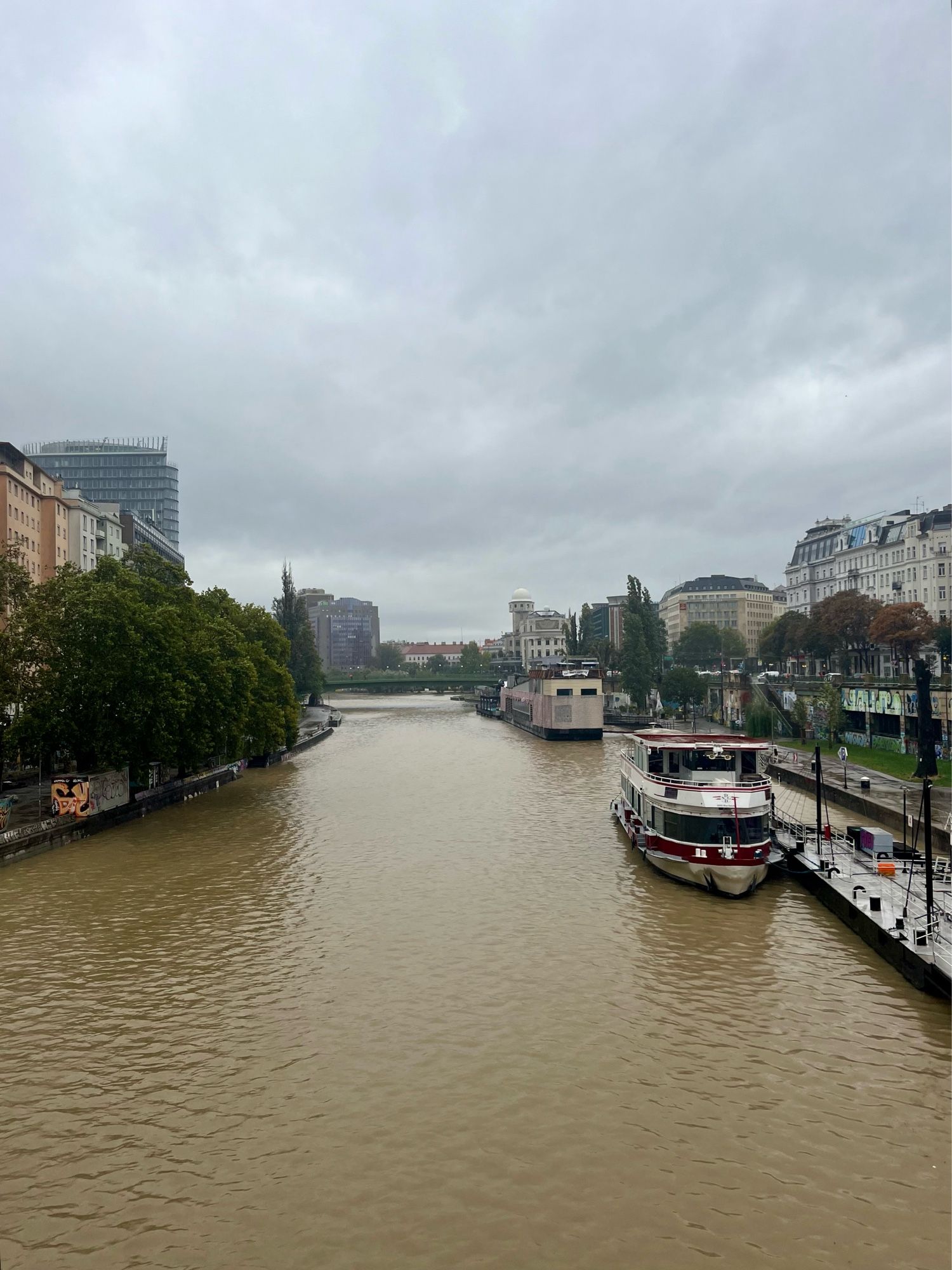 wien schwedenplatz, aufnahme richtung prater. eine breiter brauner fluss fließt durch die stadt.