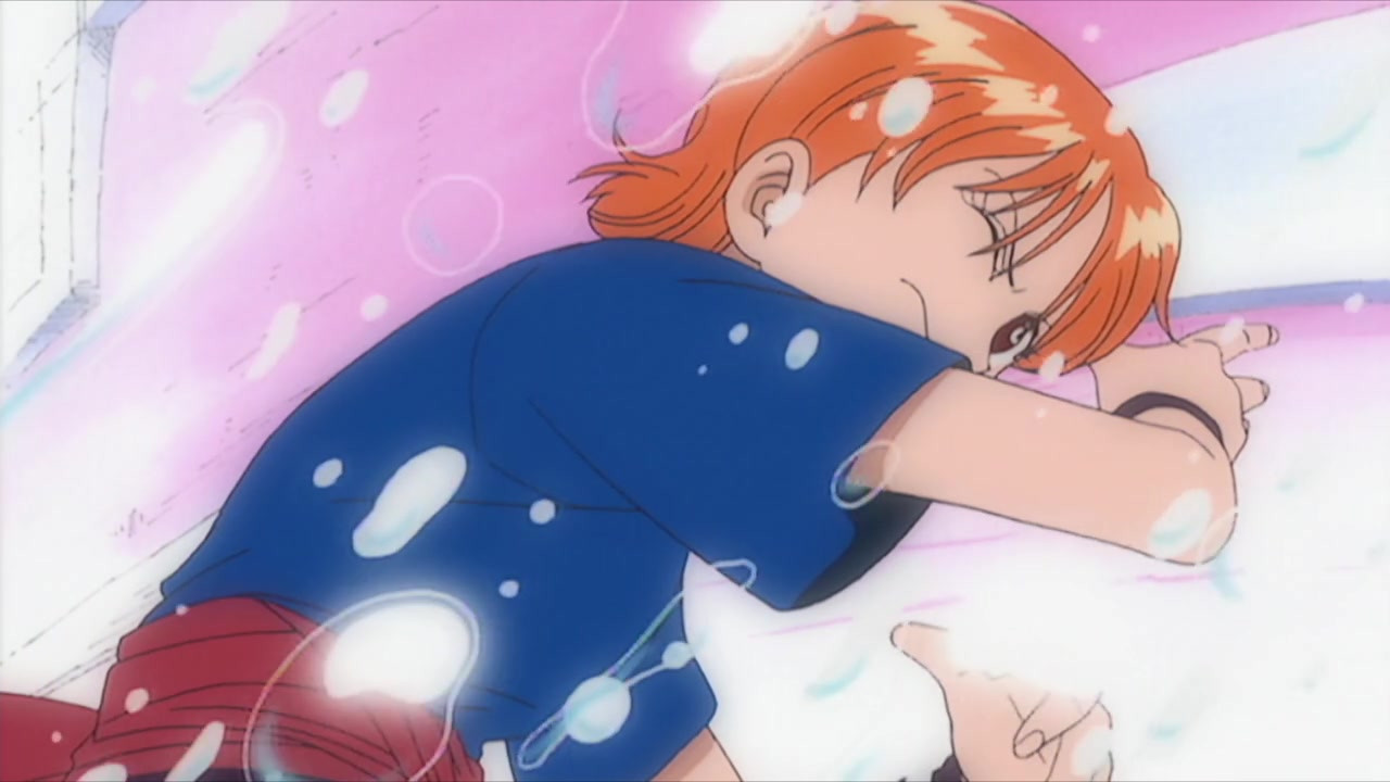 a frame of nami from episode 1 of one piece, featuring nami.

she is leaning away from the camera, as the spray of bubbles from the previous frame hits her. with her right arm raised in front of her, and her right eye closed against the spray, she is looking to camera with an annoyed expression. she is wearing a dark blue, short sleeved top; a red sash around her waist, and a dark band around her wrist.

behind nami, the background is pink, with a white band coming from the top of her head to the left side of the frame and more wrapping around the top left of the frame. this is the side of a boat behind her. around the frame, the colours fade out into a white, to give the scene extra importance as she and luffy cross paths for the first time.