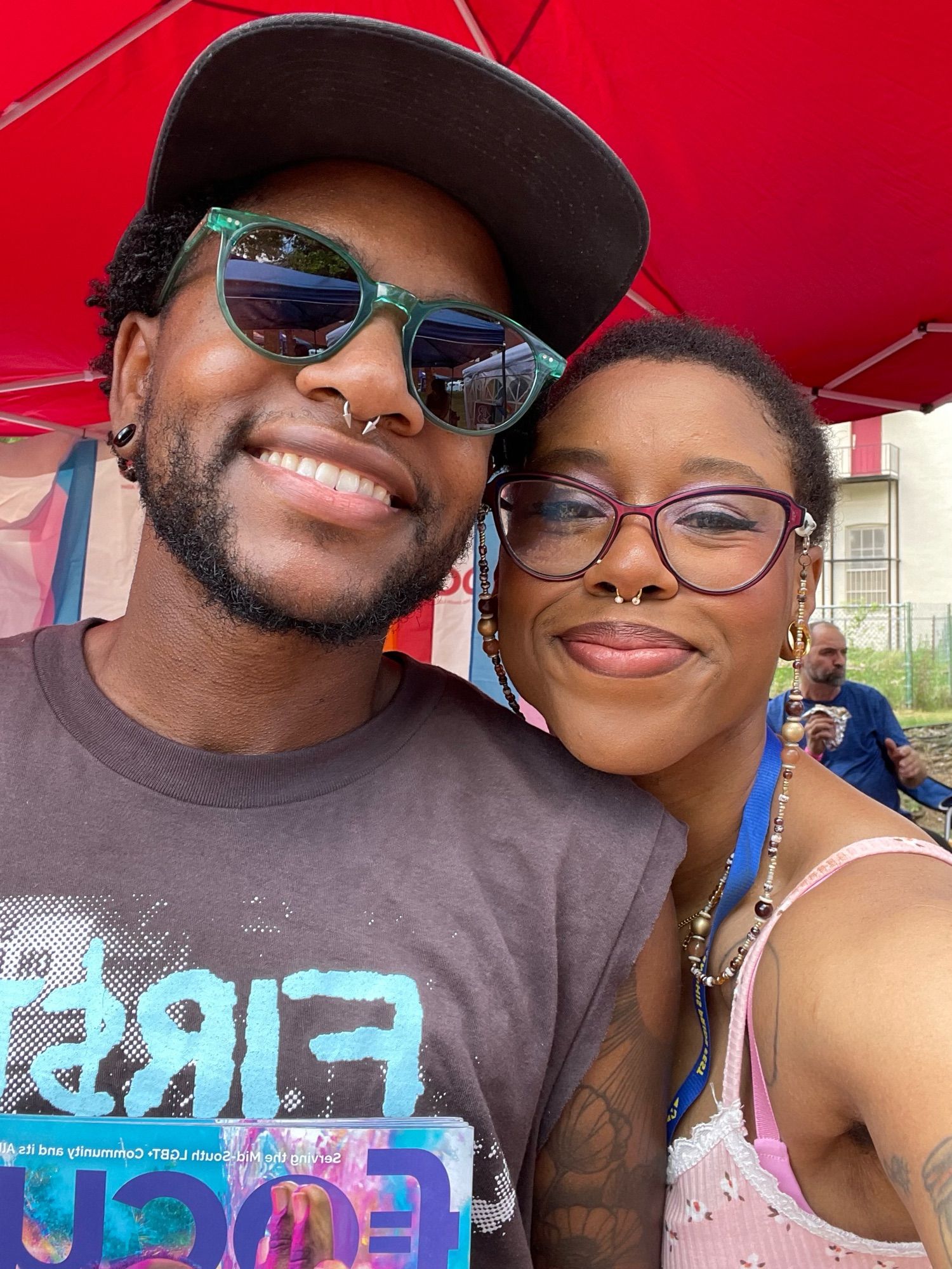 Joi and Jasper smiling outside under a red tent