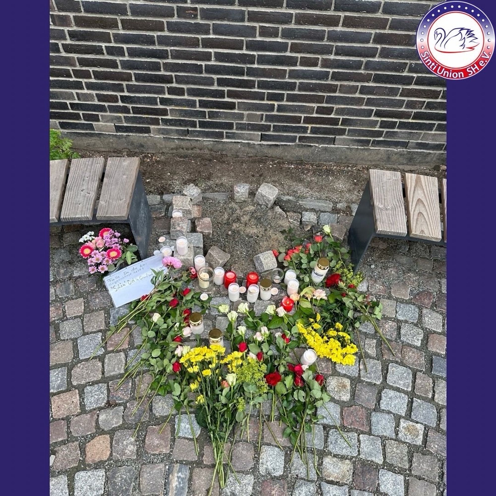 Blumen und Kerzen liegen an dem Ort, an dem die Gedenkstele stand.