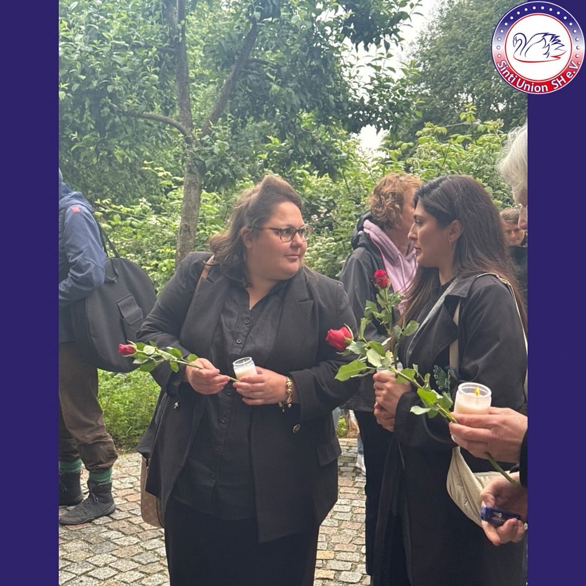 Kelly Launinger und Sahar Alias im Gespräch. Beide halten eine Rose und eine Kerze in der Hand.