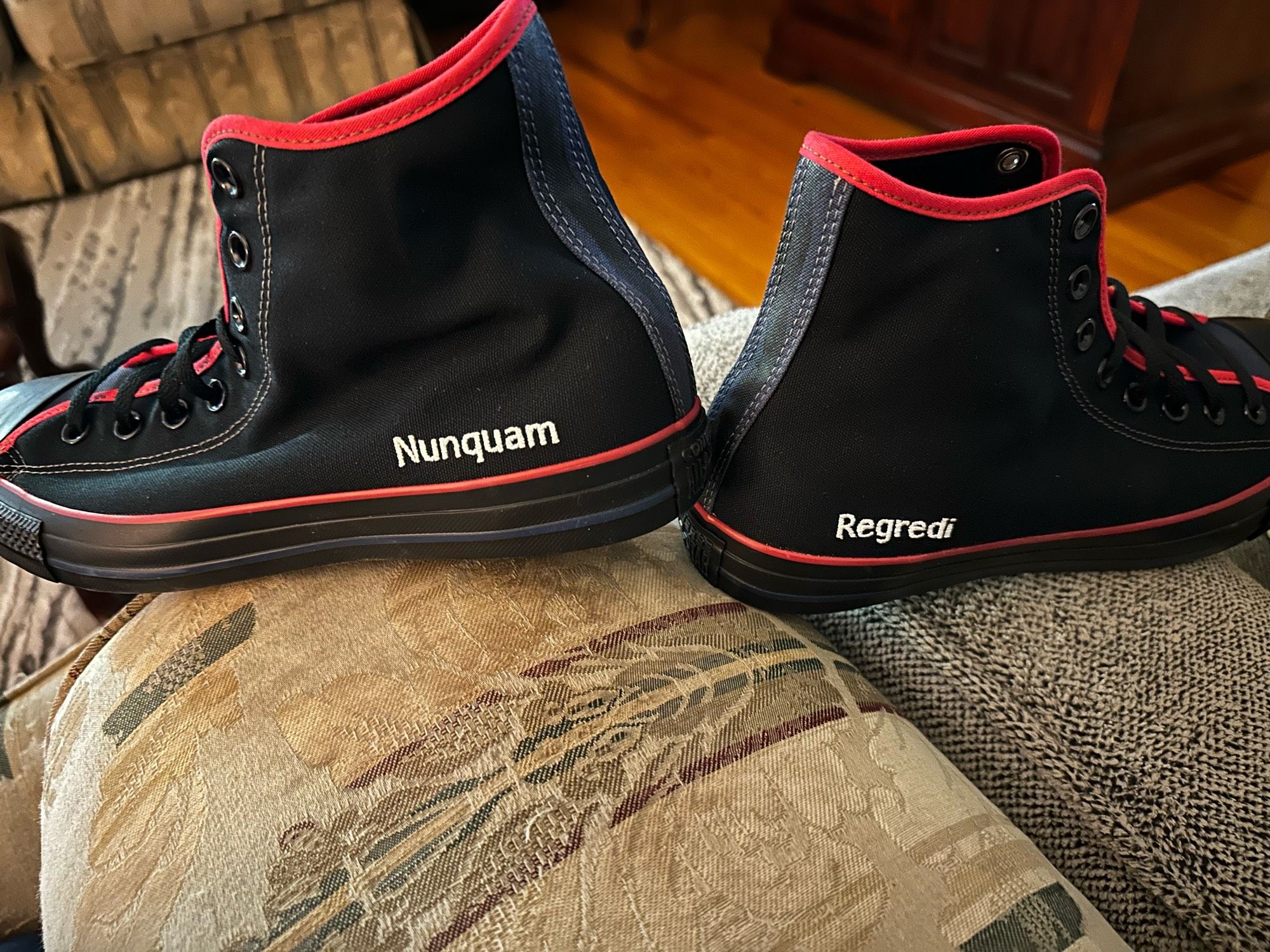 Pair of custom Converse high-top sneakers, with the Latin words “Nunquam Regredi” them.