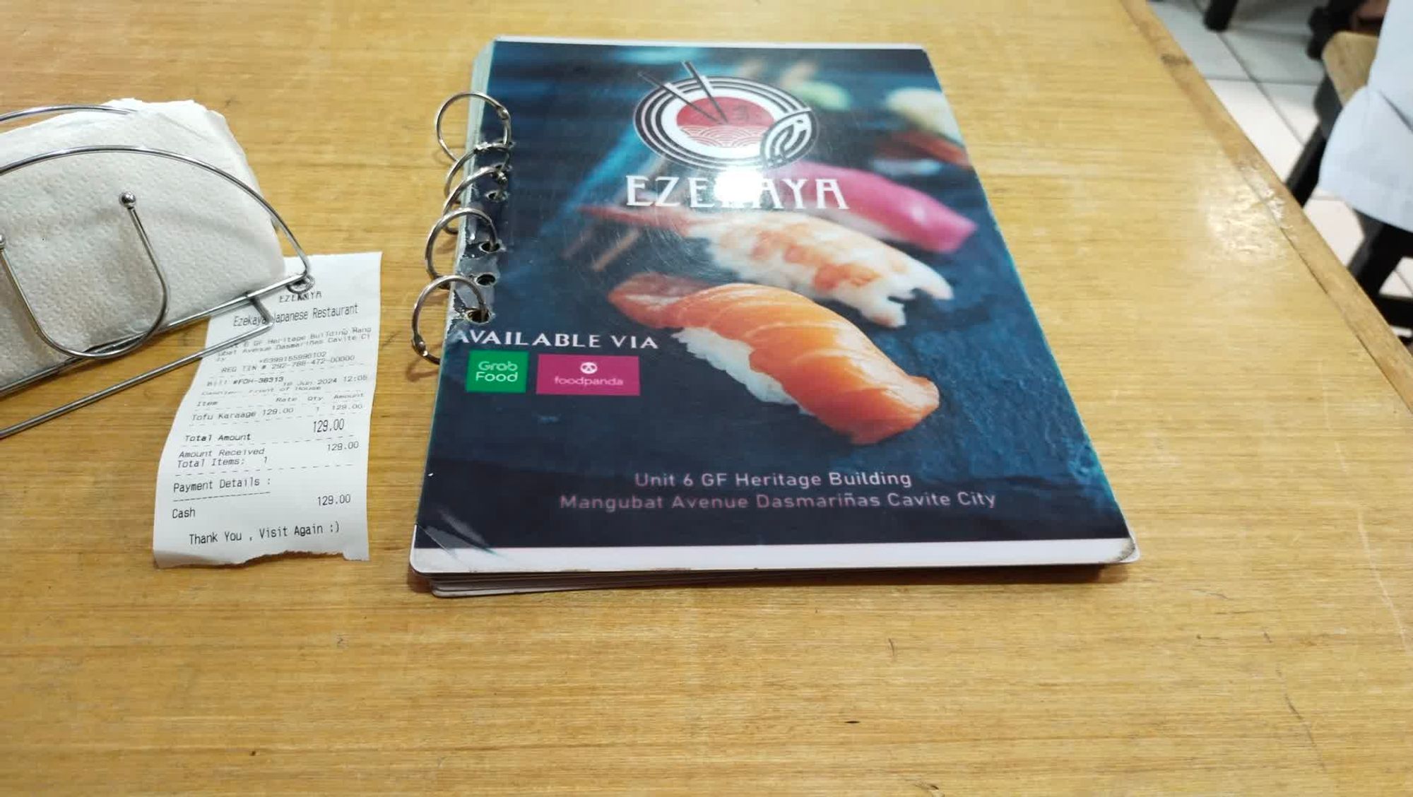 A menu book of Ezekaya Japanese Restaurant alongside a receipt.