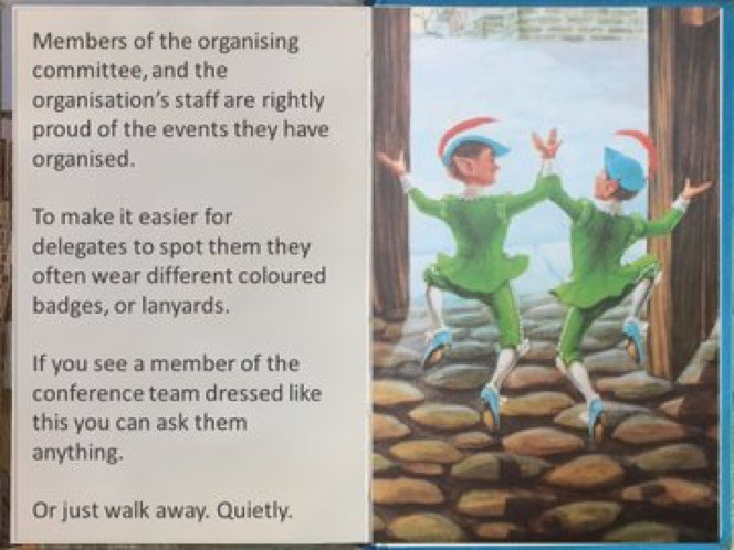 Picture of an open book, with text on one side and a picture of two short elves wearing green, and blue hats with red feathers, dancing a jig.  The text reads,"Members of the organising committee, and the organisation staff are rightly proud of the events they have organised.  To make it easier for delegates to spot them, they often wear different coloured badges or lanyards.  If you see a member of the conference team dressed like this, you can ask them anything.  Or just walk away.  Quietly."