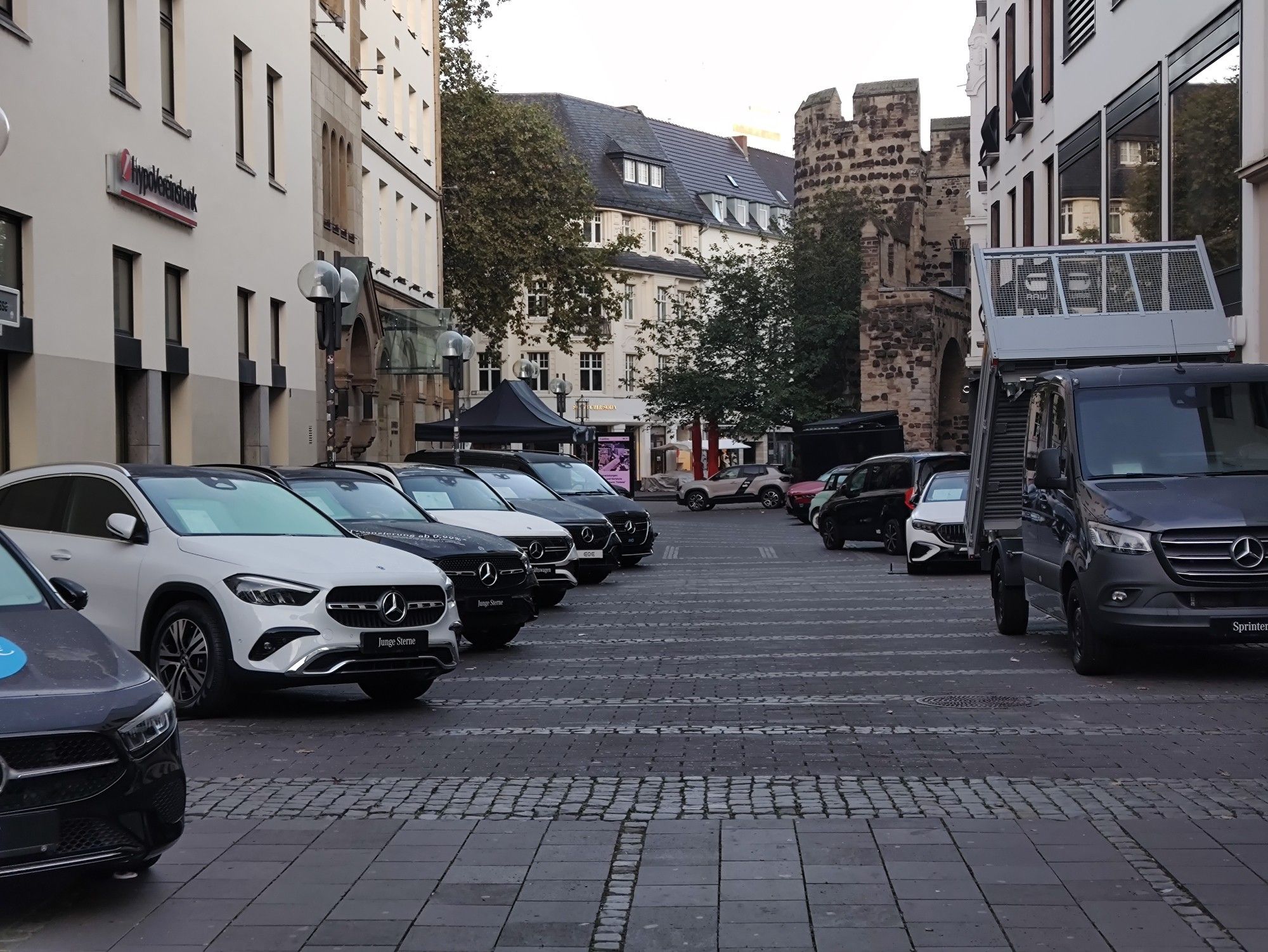 Blick vom Münsterplatz in die Vivatsgasse und auf das Sterntor. Rechts und links sind lange Reihen von Autos aufgestellt. Es sind keine Menschen zu sehen.