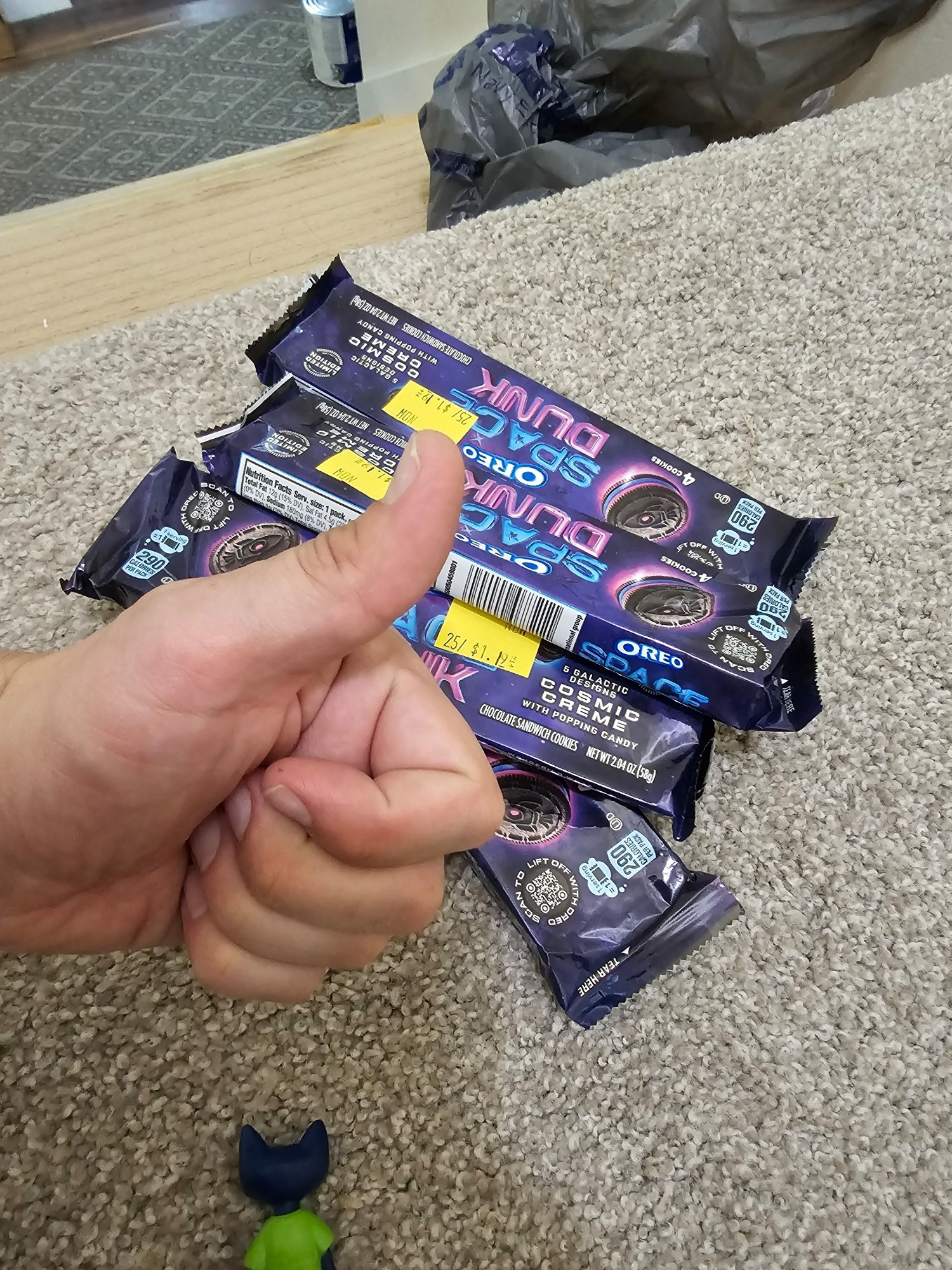 A picture of a hand giving a thumbs up in front of four packs of space dunk Oreos