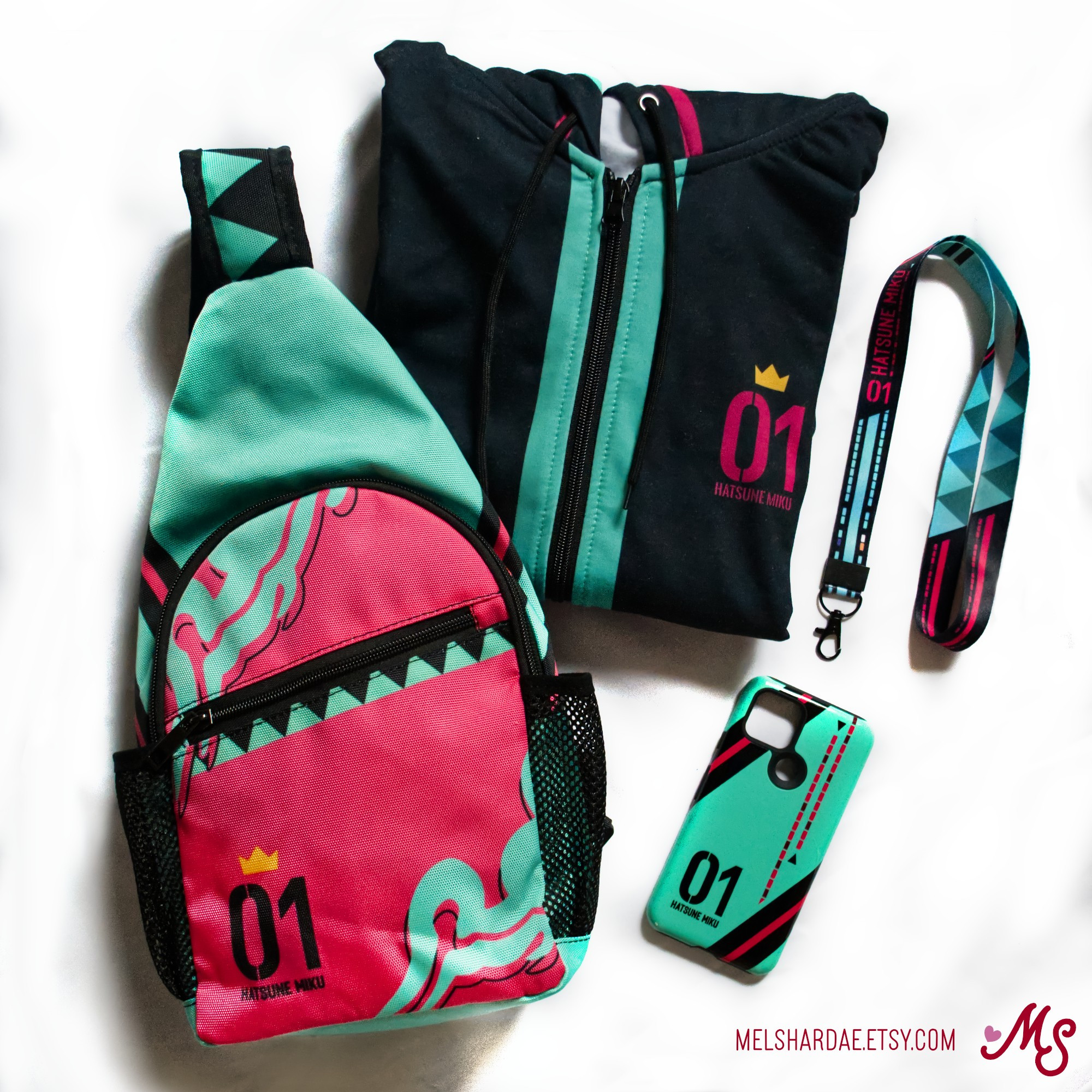 Photo of a flat lay of several Hatsune Miku-themed garments - a sling bag, a folded zip hoodie, a lanyard, and a phone case.