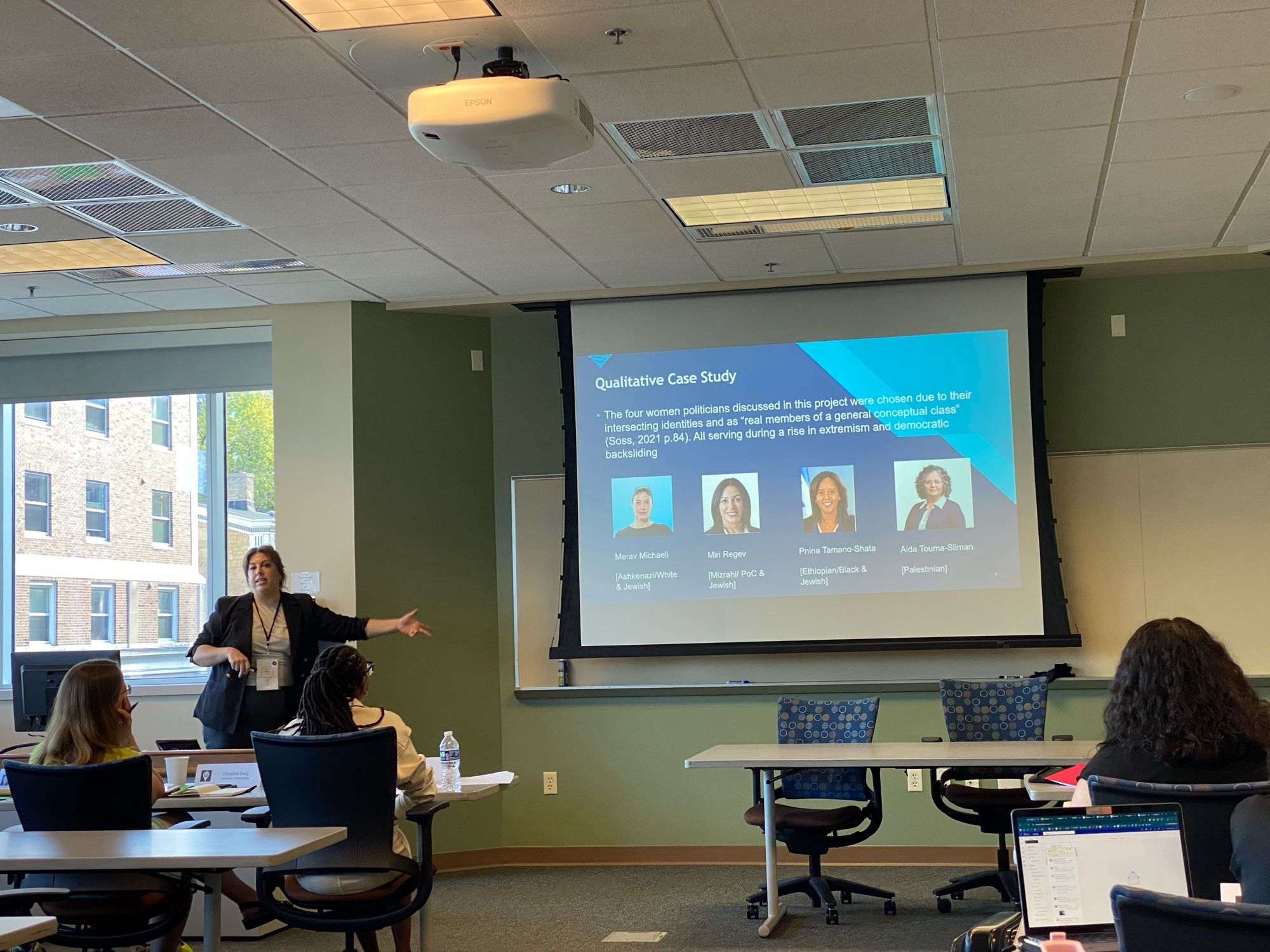 Woman presents slides in a conference room.