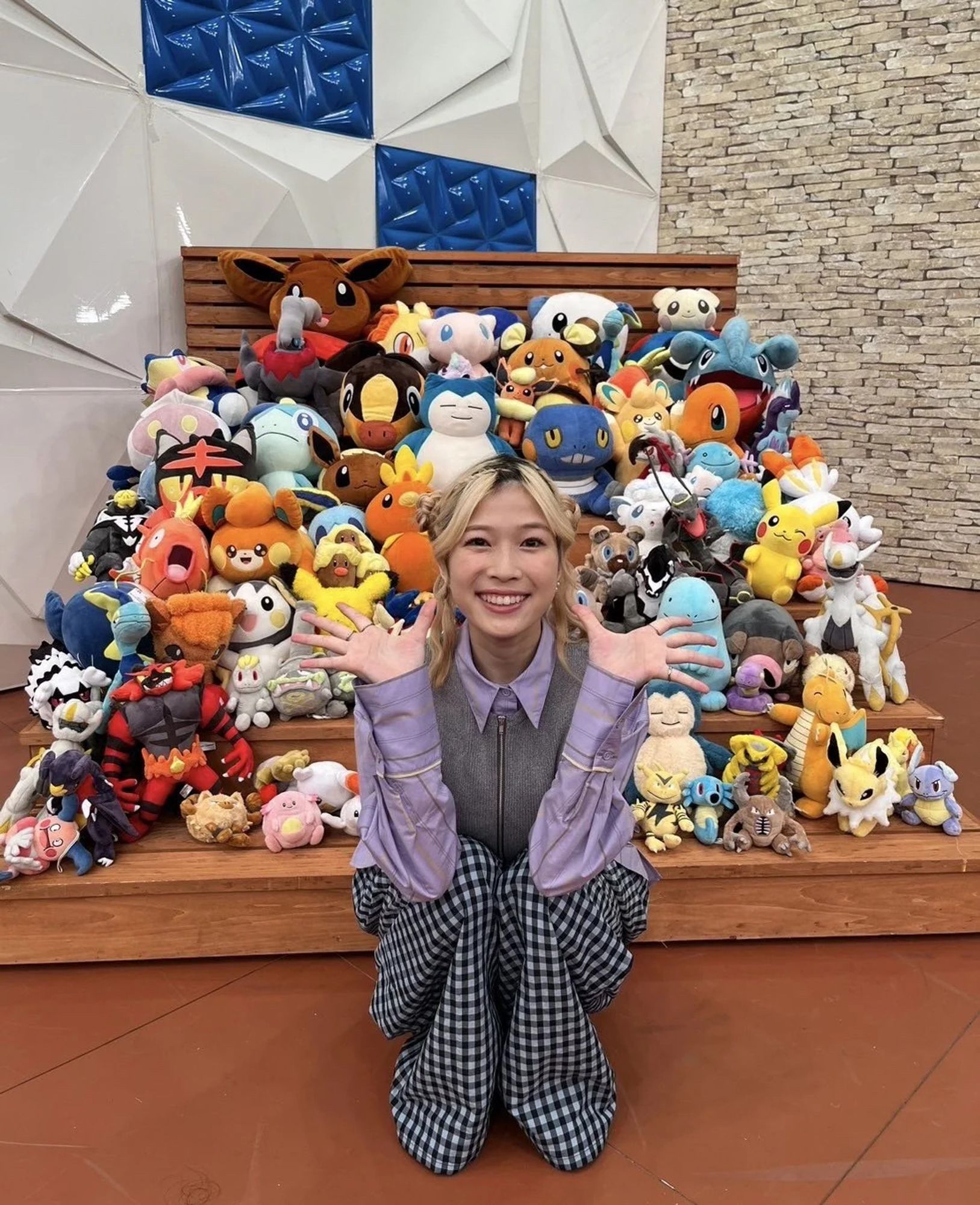 Yoshino with a large display of Pokemon plushes.