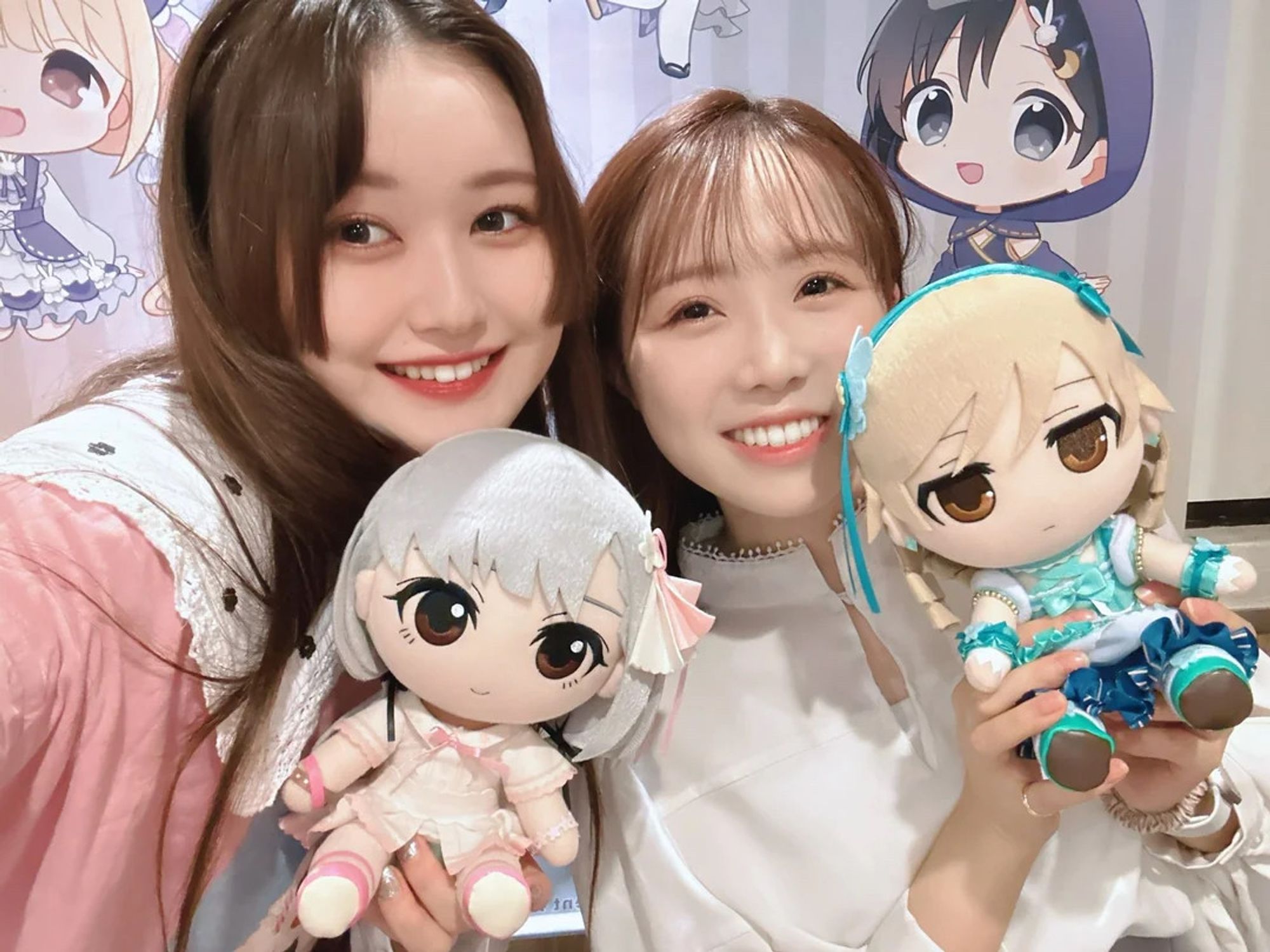 Hina and Karin smiling with Hisakawa Nagi and Morikubo Nono plushes.