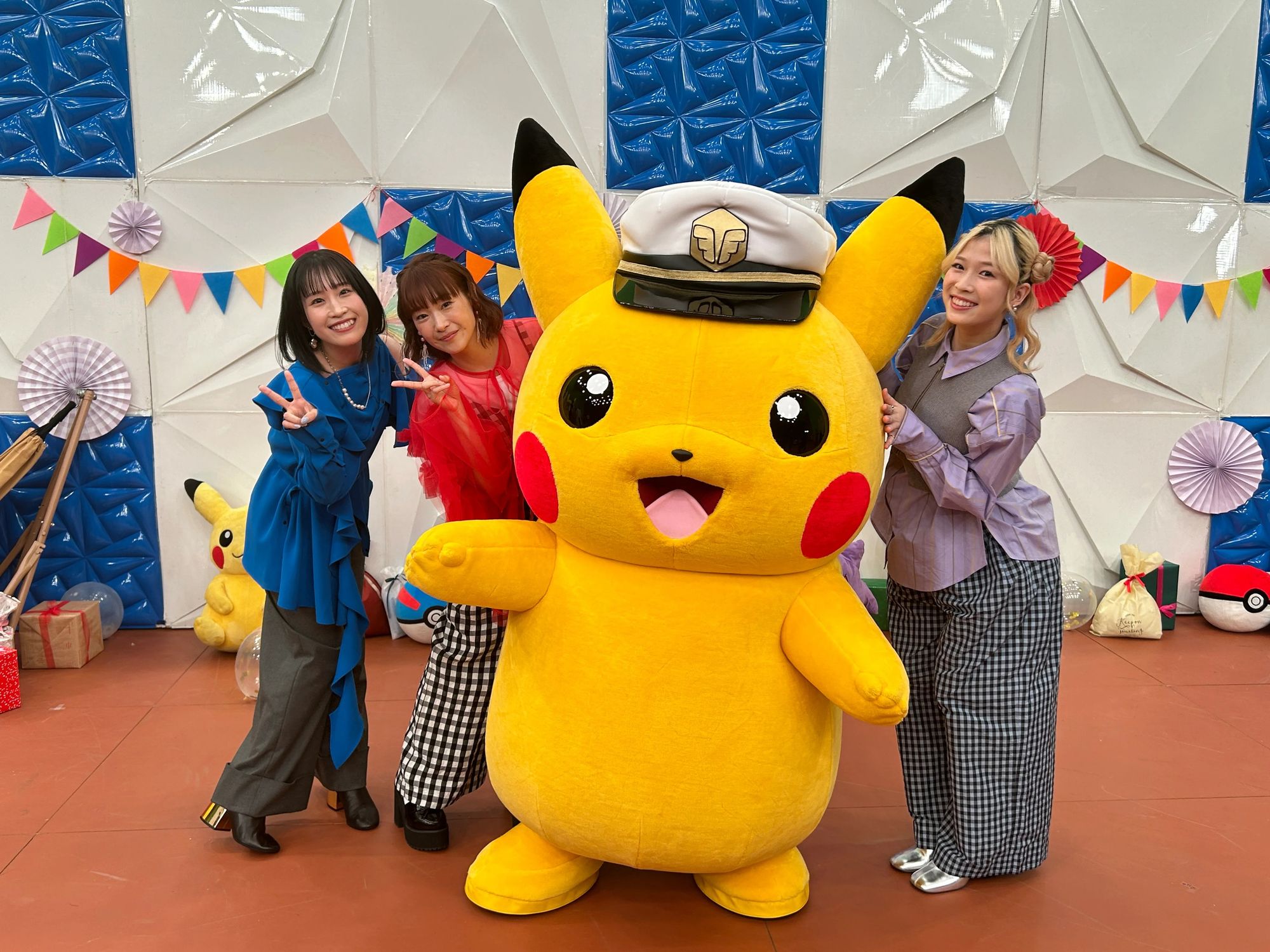 Minori, Yuka, and Yoshino posing with a Pikachu wearing a sailor hat.