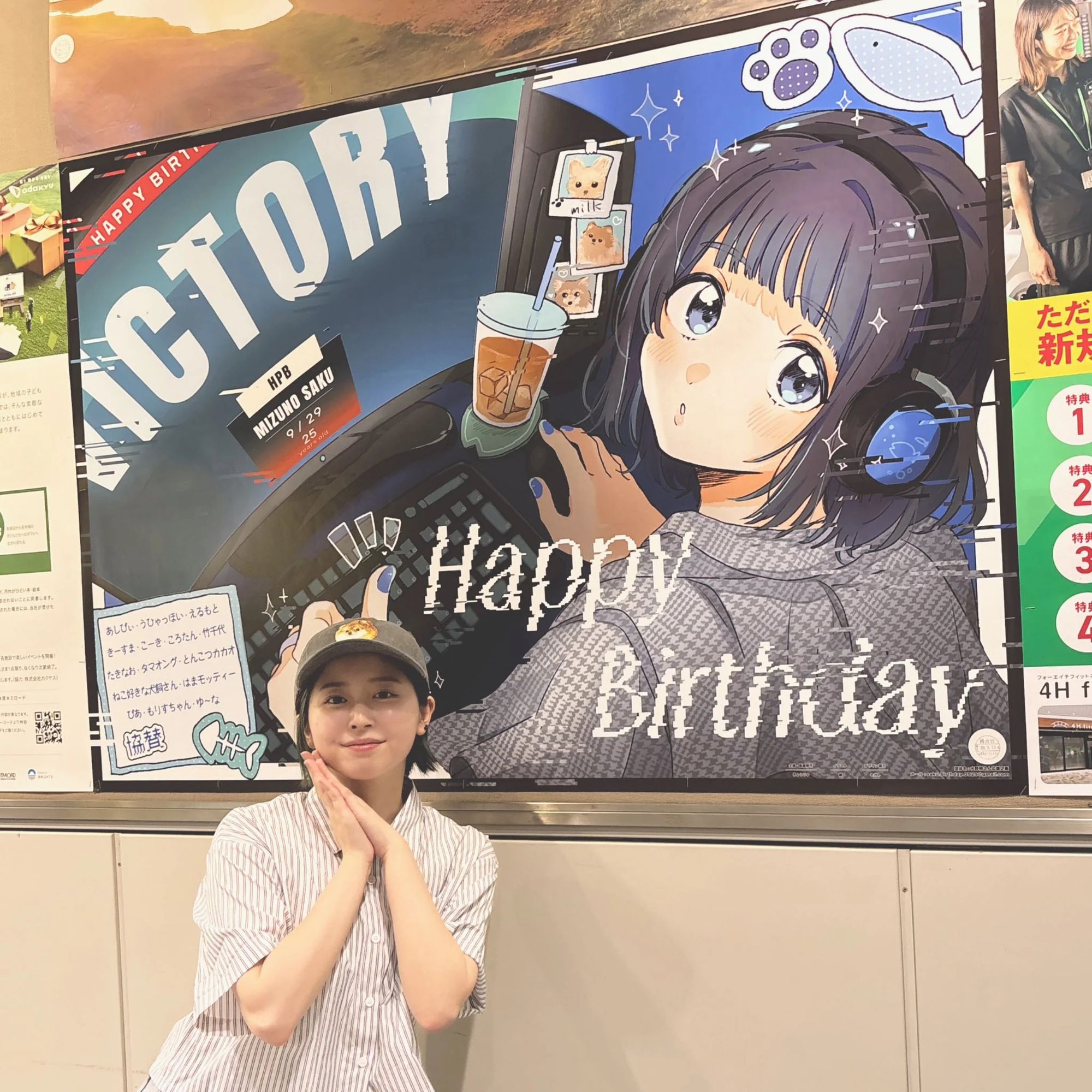 Saku with her Happpy Birthday sign showing her self drawn in anime form at a computer wearing headphones.