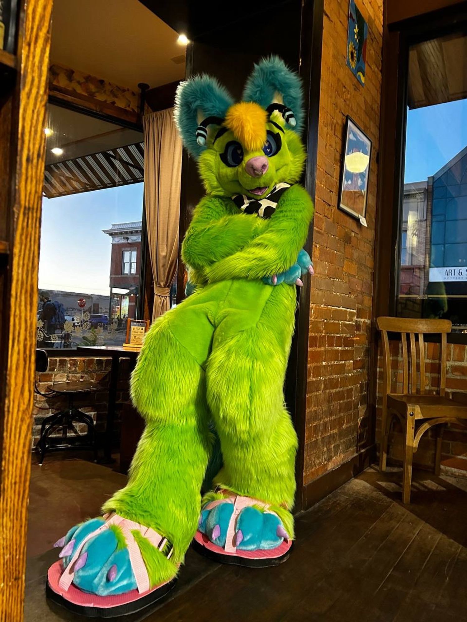 Cool alien chihuhua fursuit leaning in a doorway