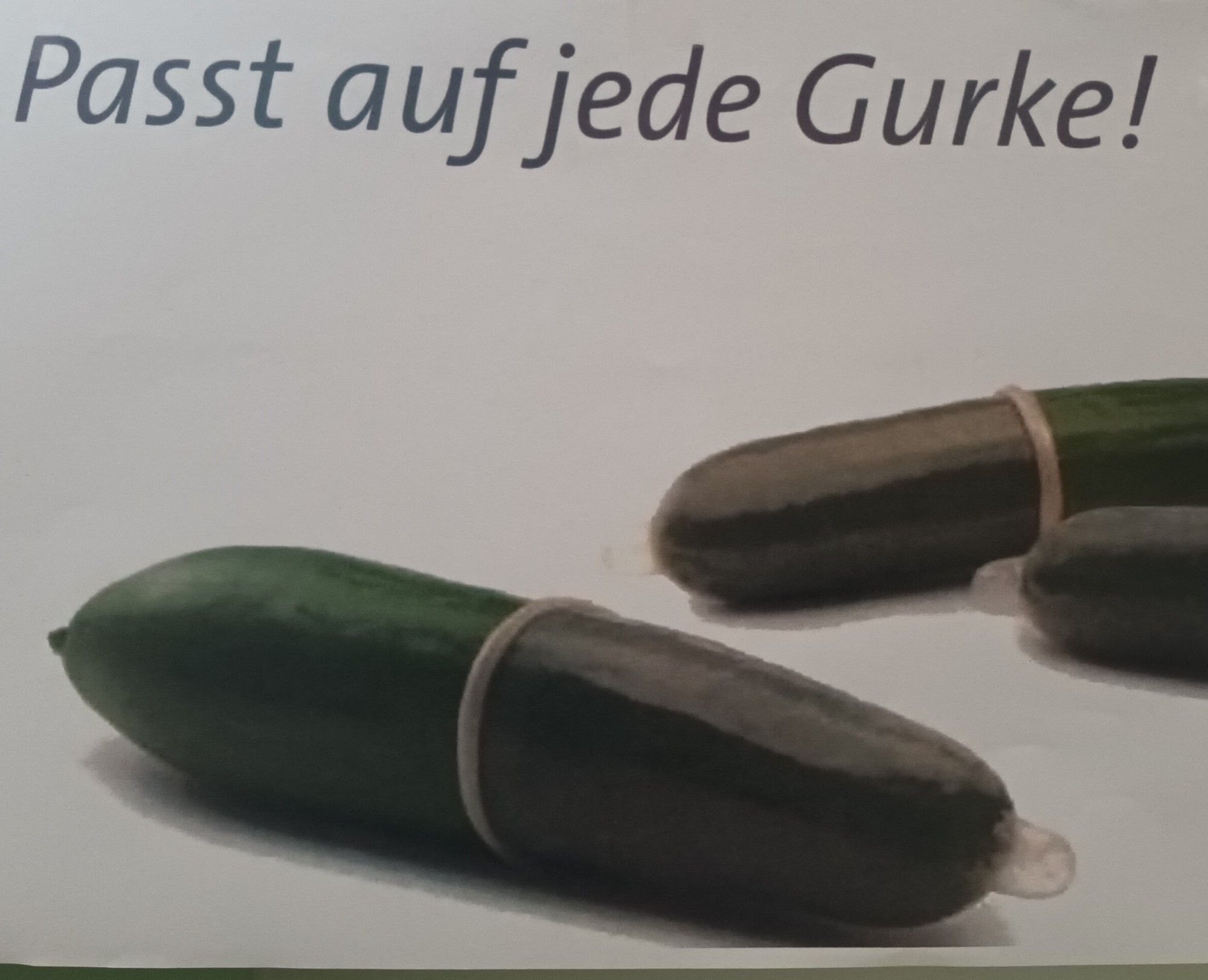 Werbeposter:  Gurken mit Kondom, mit dem Text: "passt auf jede Gurke"