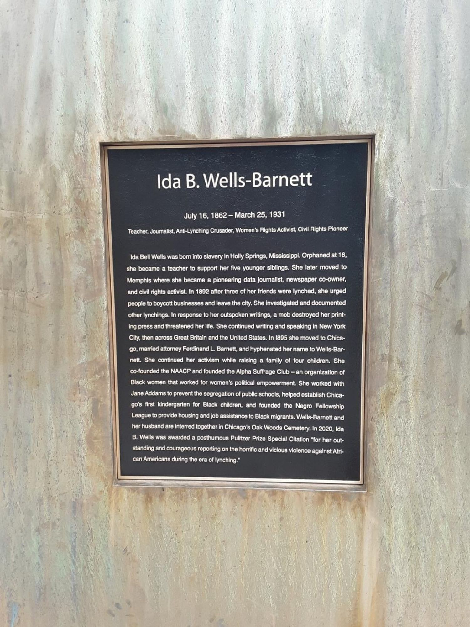 A plaque dedicated to Ida B. Wells-Barnett. It provides a brief biography, highlighting her roles as a teacher, journalist, anti-lynching crusader, women's rights activist, and civil rights pioneer. The text covers her birth, achievements, and contributions to civil rights.