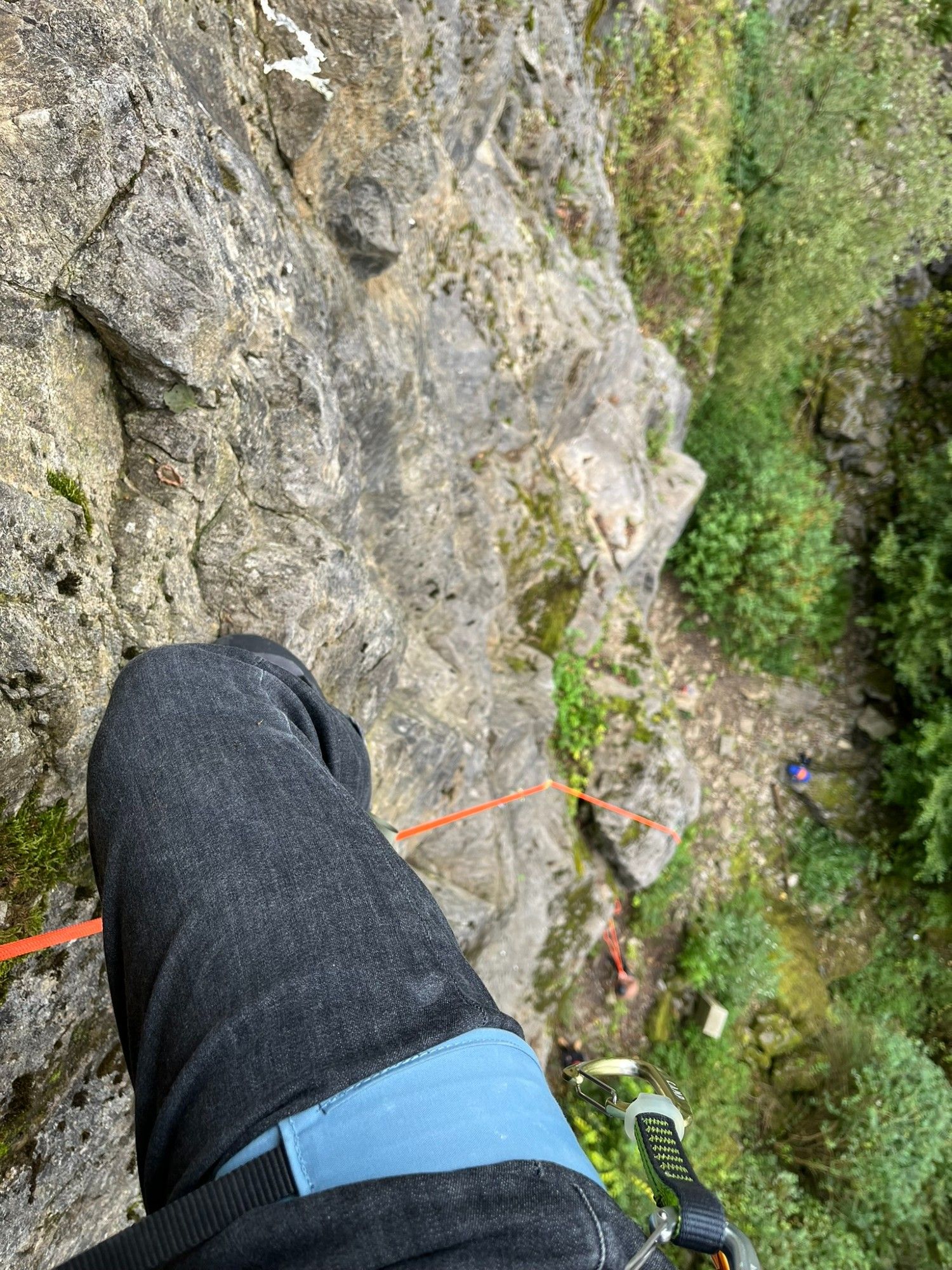 Und ein Blick nach unten, man sieht mein rechtes Bein (schwarze Hose, graublauer Klettergurt wo noch eine Exe dranhängt)