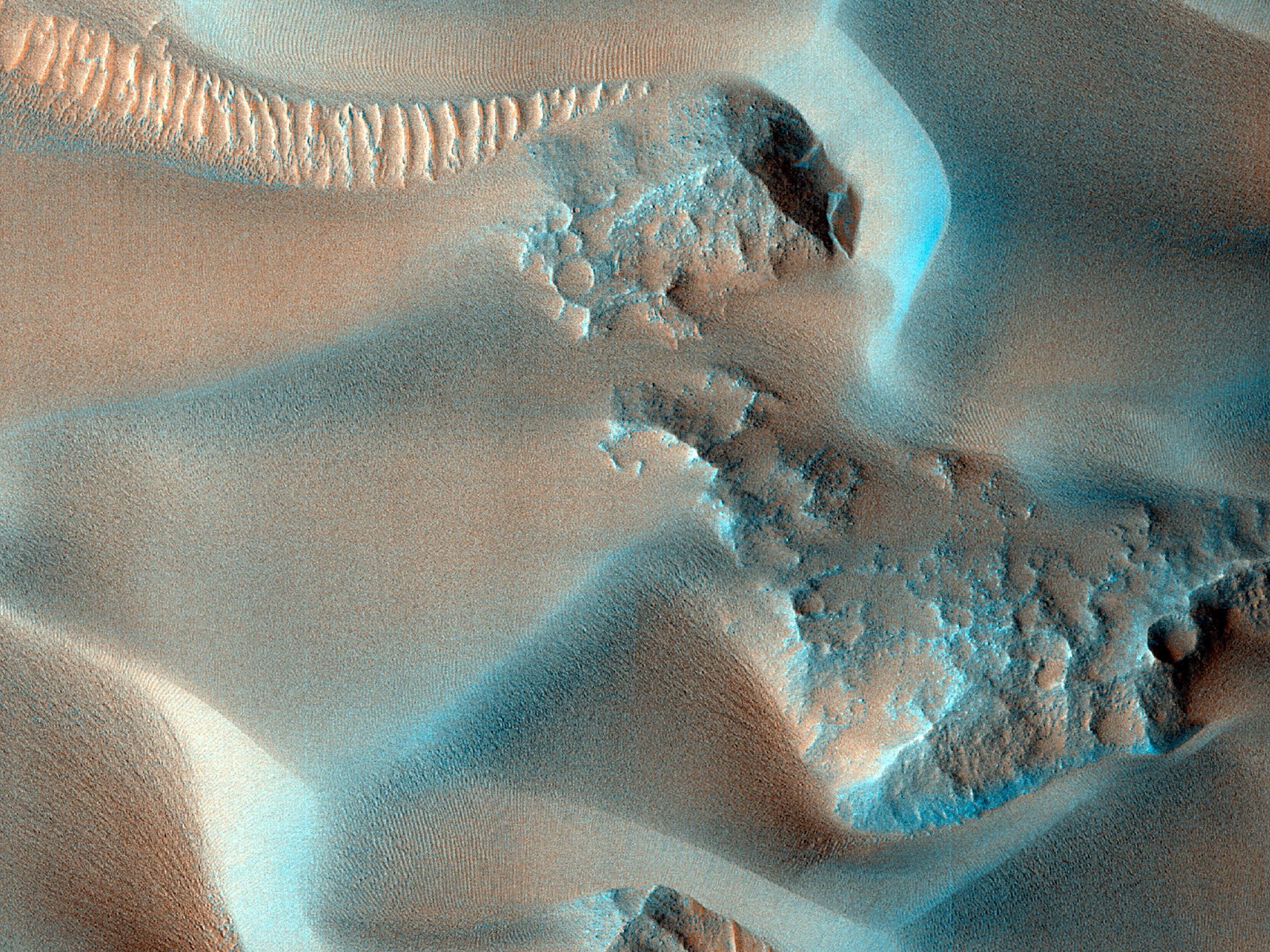 Enhanced color cutout shows a closeup of a rocky outcrop and a large dune sheet. (NASA/JPL-Caltech/University of Arizona)