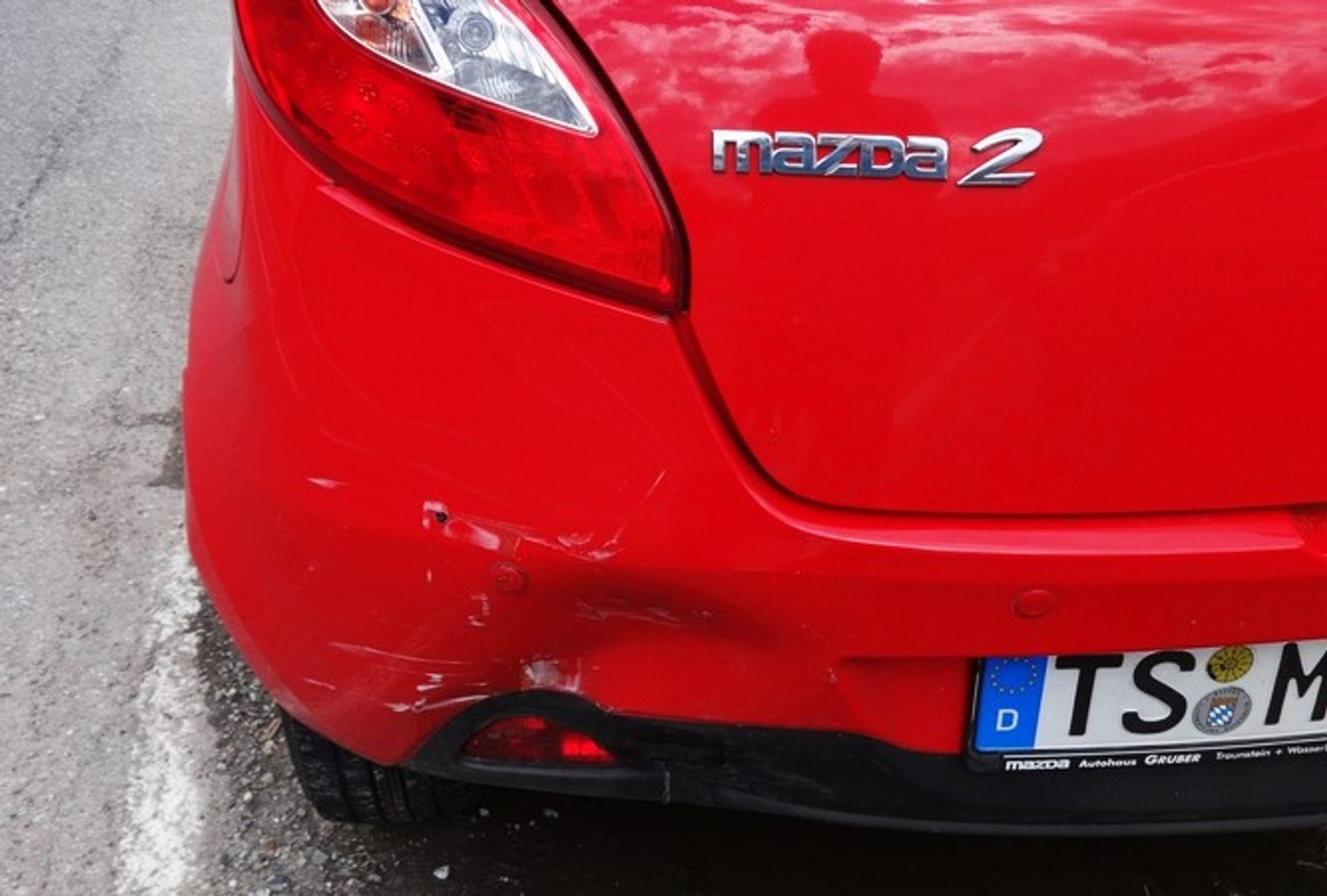 das bild zeigt einen roten mazda 2-er mit aufffahrschaden. der hintermir fahrende hat mein rechtsabbiegen übersehen, italien, sonico 2021