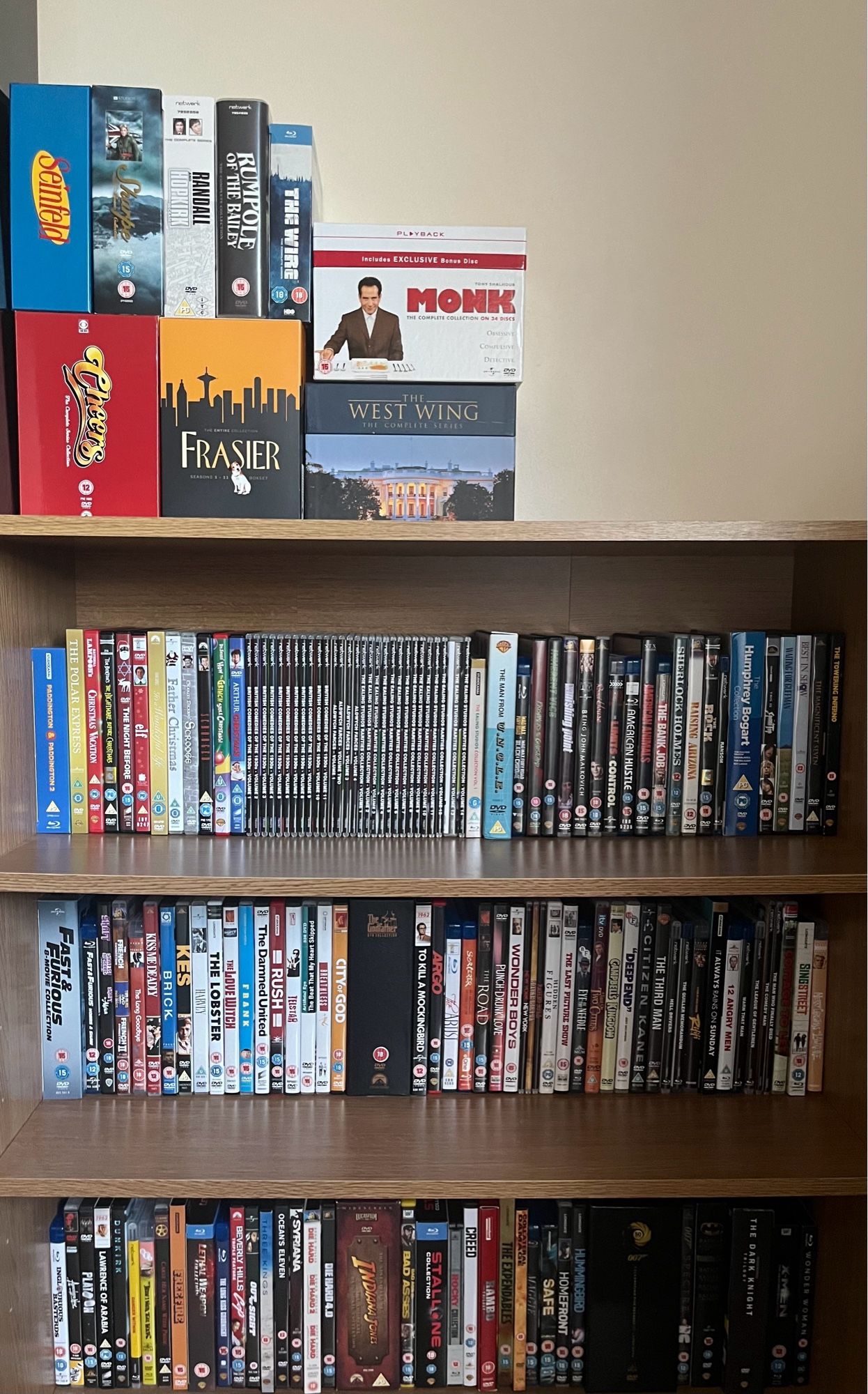 A bookcase full of DVDs and Blu-Rays of films with some box sets on top.